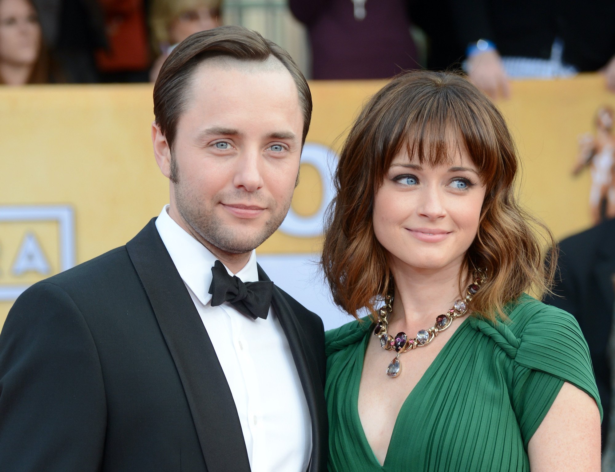 (L-R) Vincent Kartheiser and Alexis Bledel smiling in front of a blurred crowd