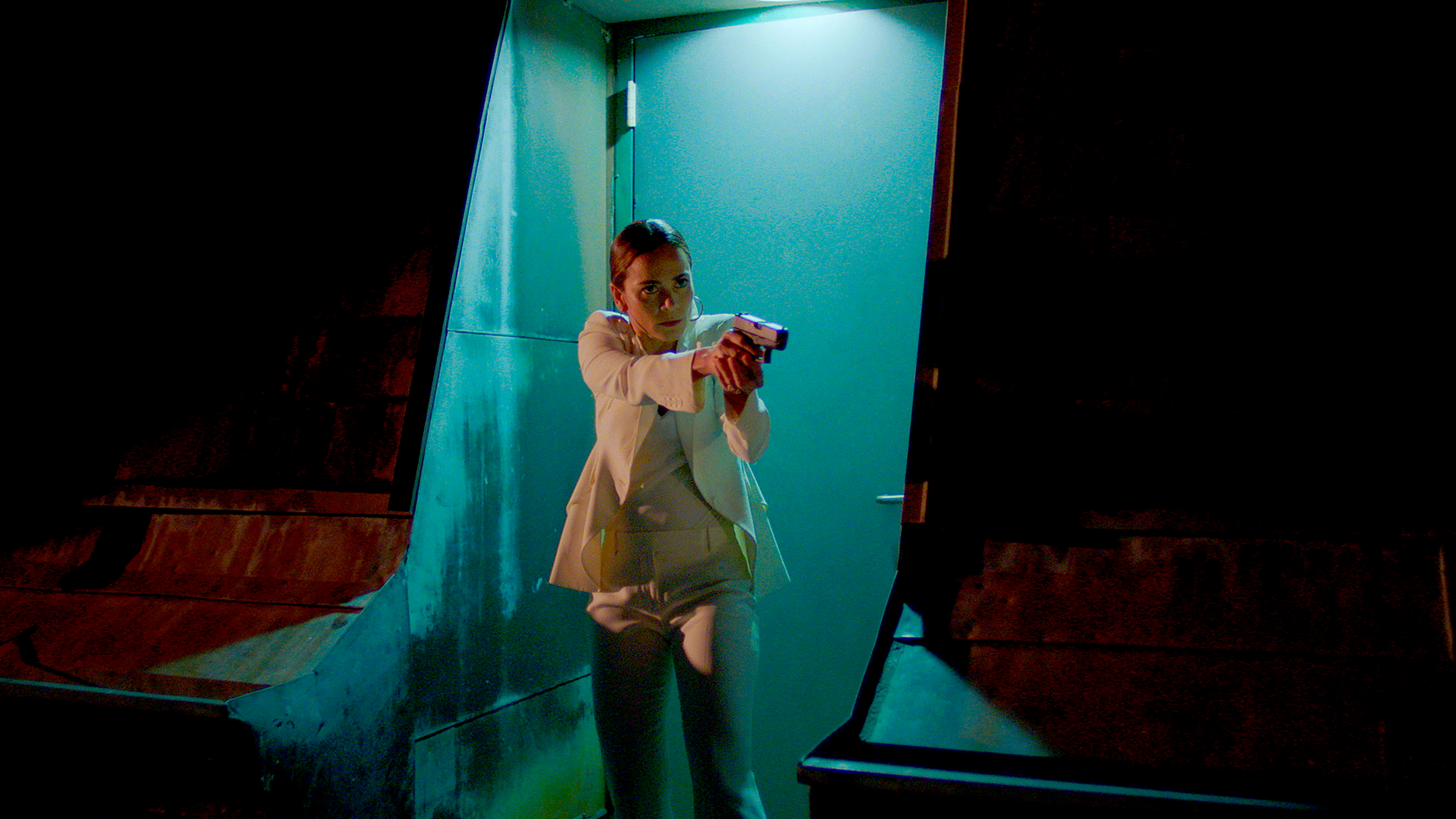 Teresa Mendoza points a gun while wearing her white suit