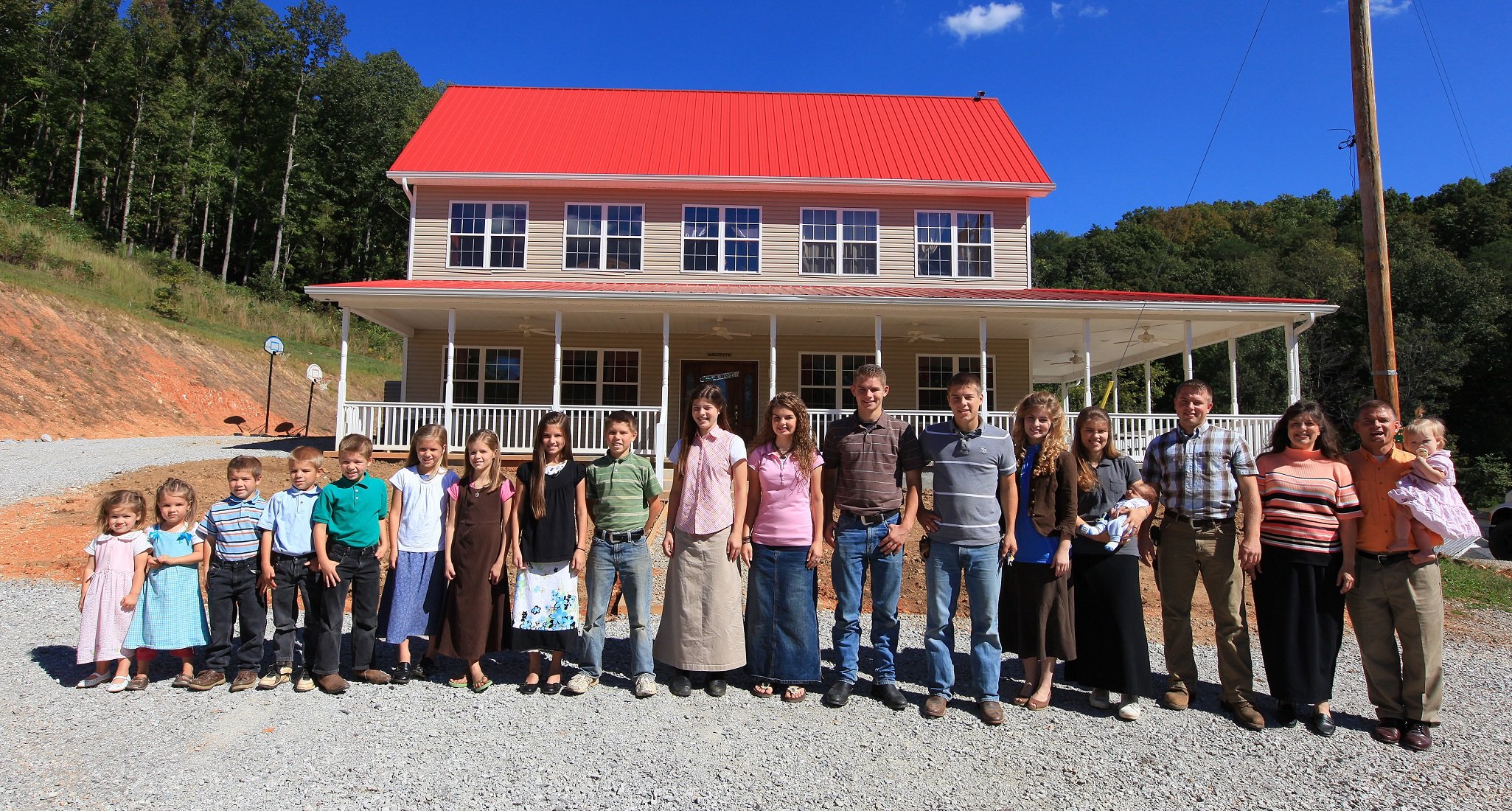 'Bringing Up Bates' stars, the Bates family, pose for a promotional photo in front of their home in Tennessee