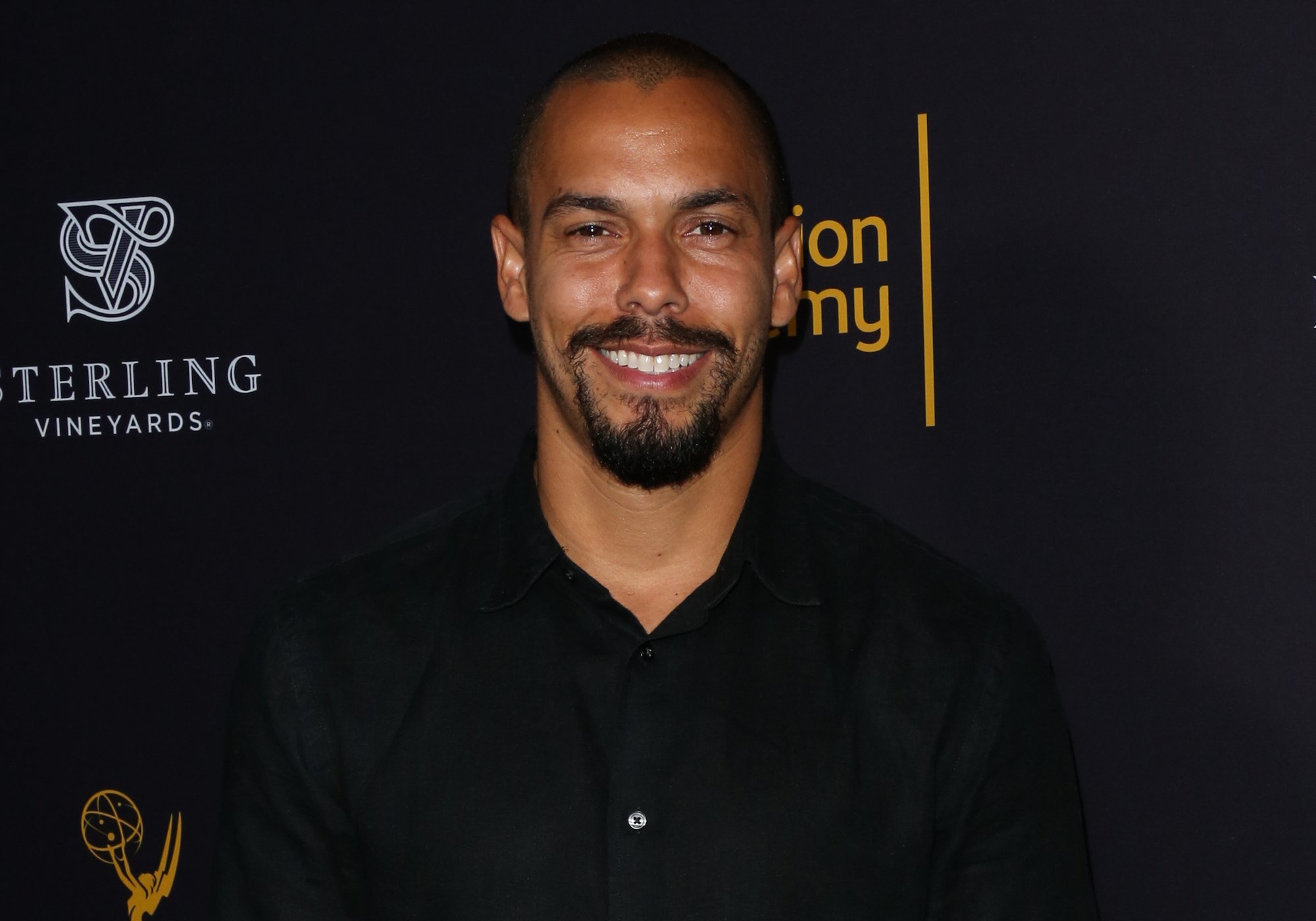 Bryton James smiling in front of a black background