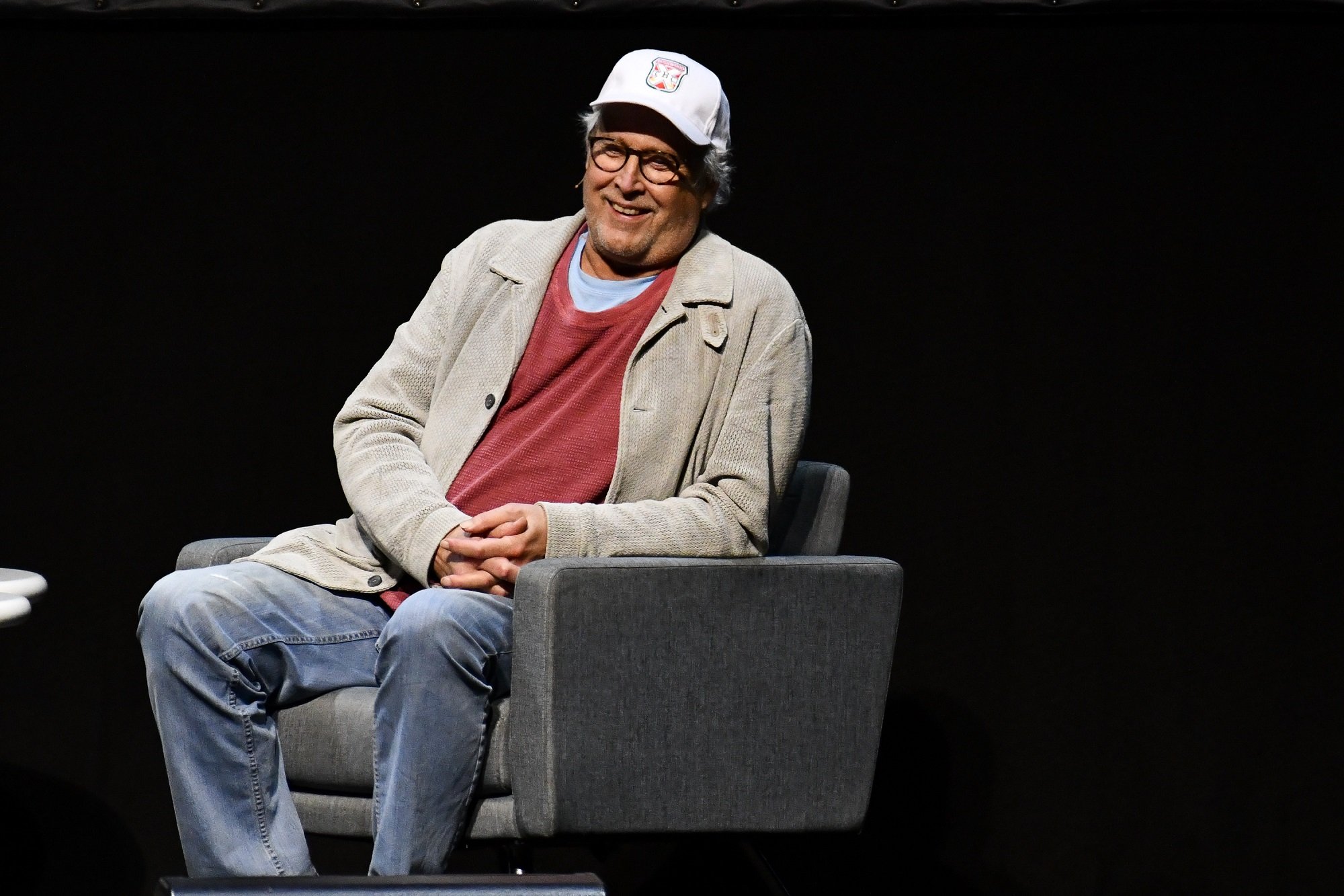 Chevy Chase sitting in a chair for a Q&A