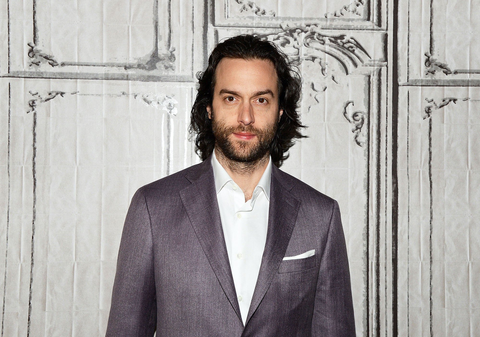 Chris D'Elia smiling in front of a white background
