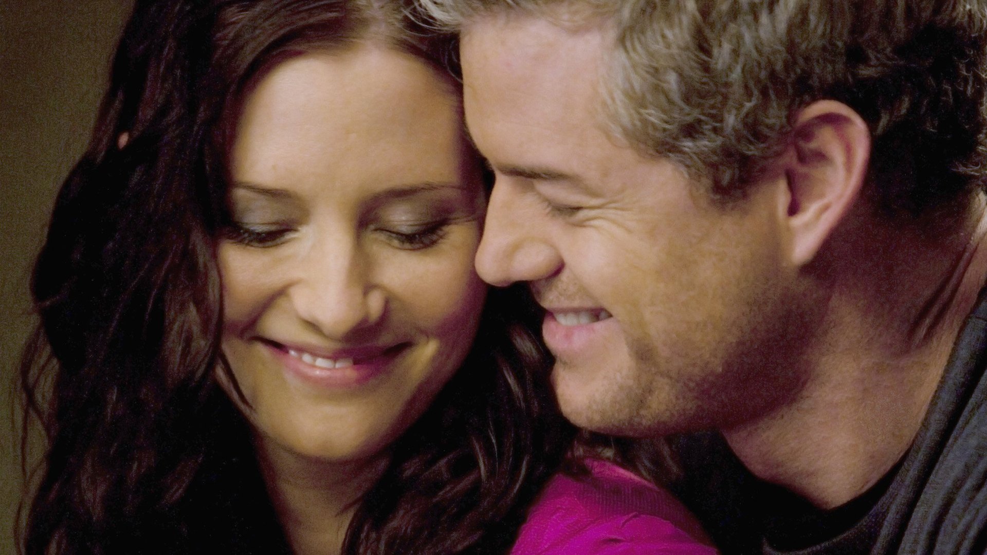 Chyler Leigh as Lexie Grey and Eric Dane as Mark Sloan smiling together in ‘Grey’s Anatomy’