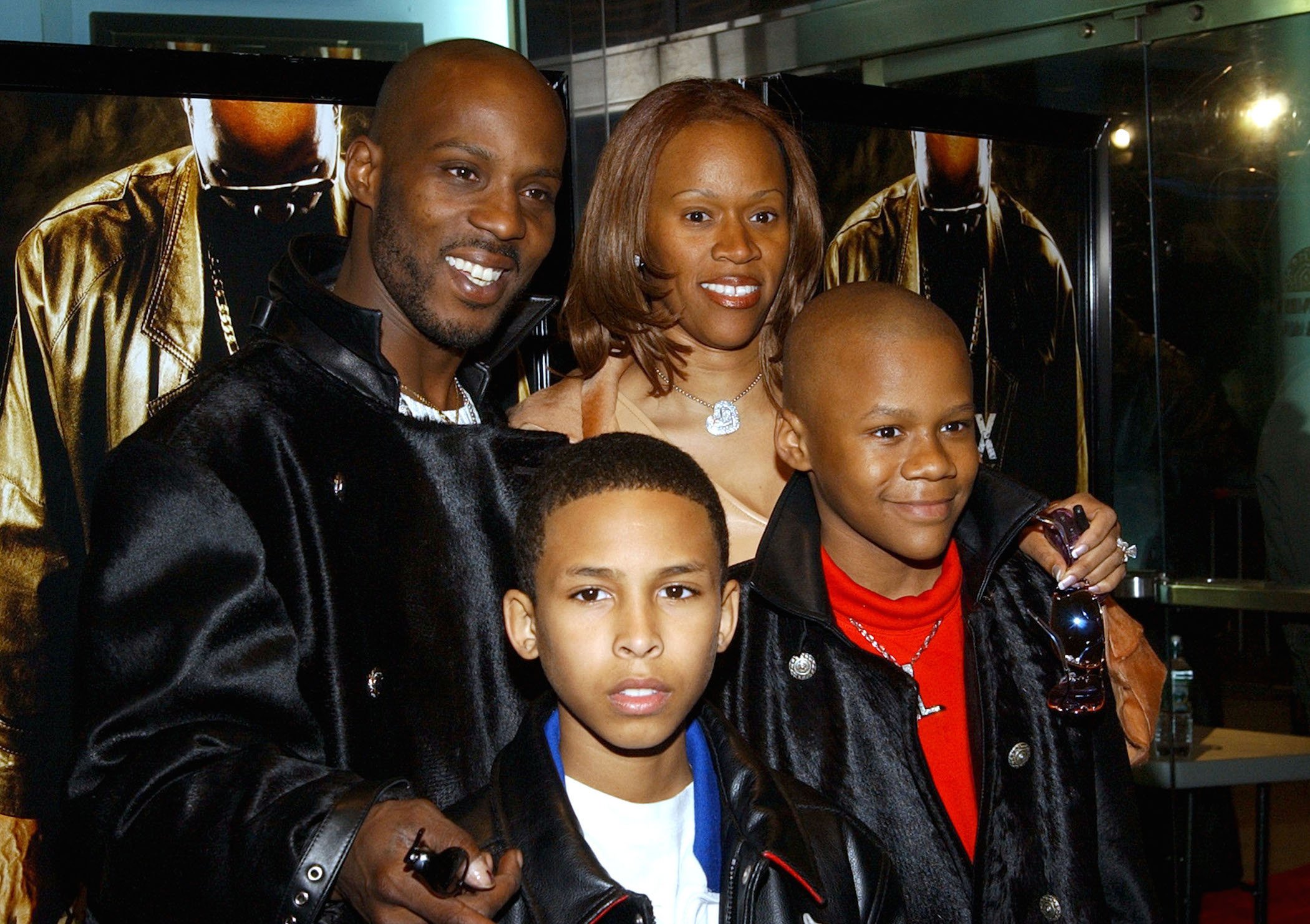 DMX's wife, Tashera Simmons, godson Jevon, and son Xavier, and DMX standing together at an event