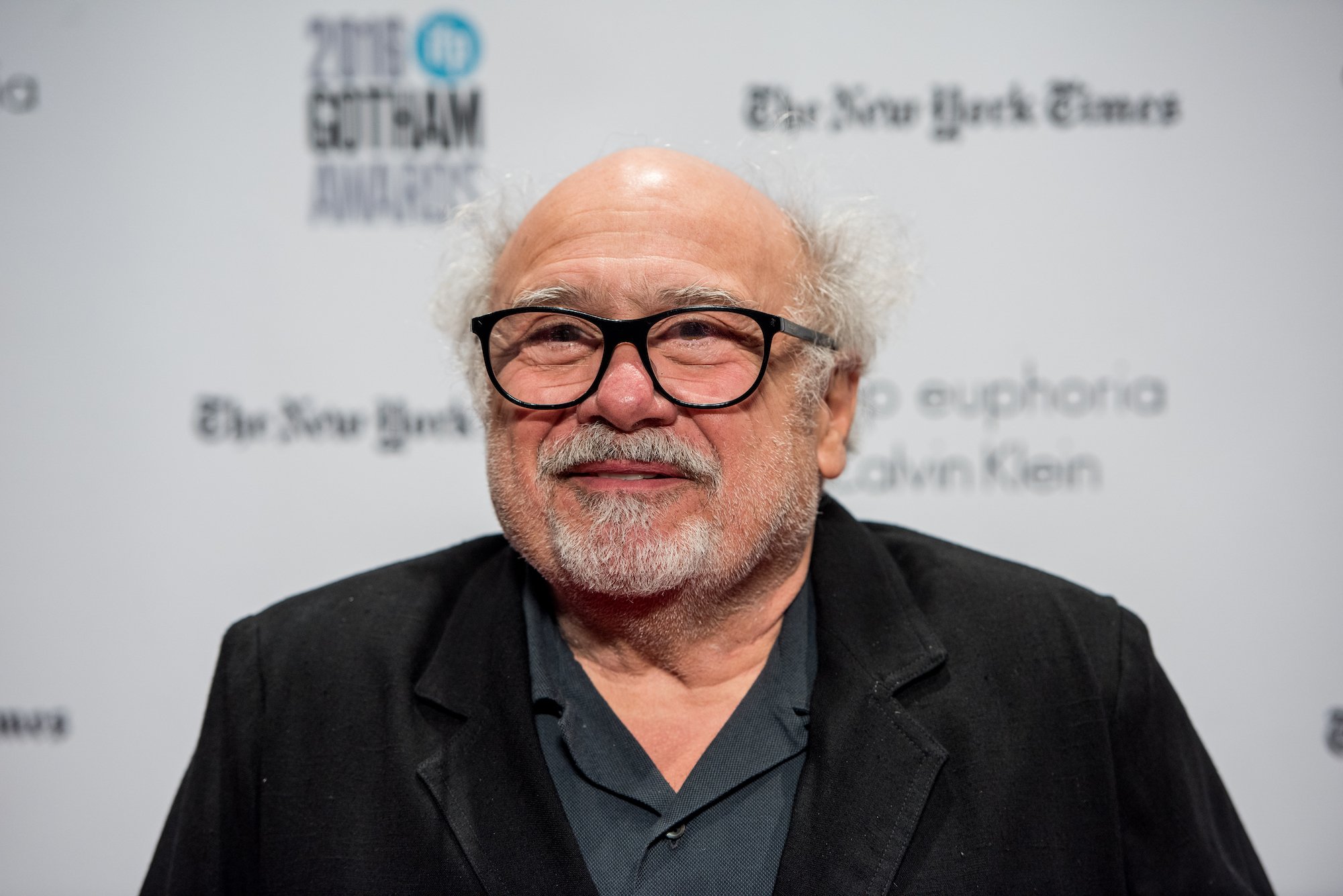 Danny DeVito smiling in front of a white background