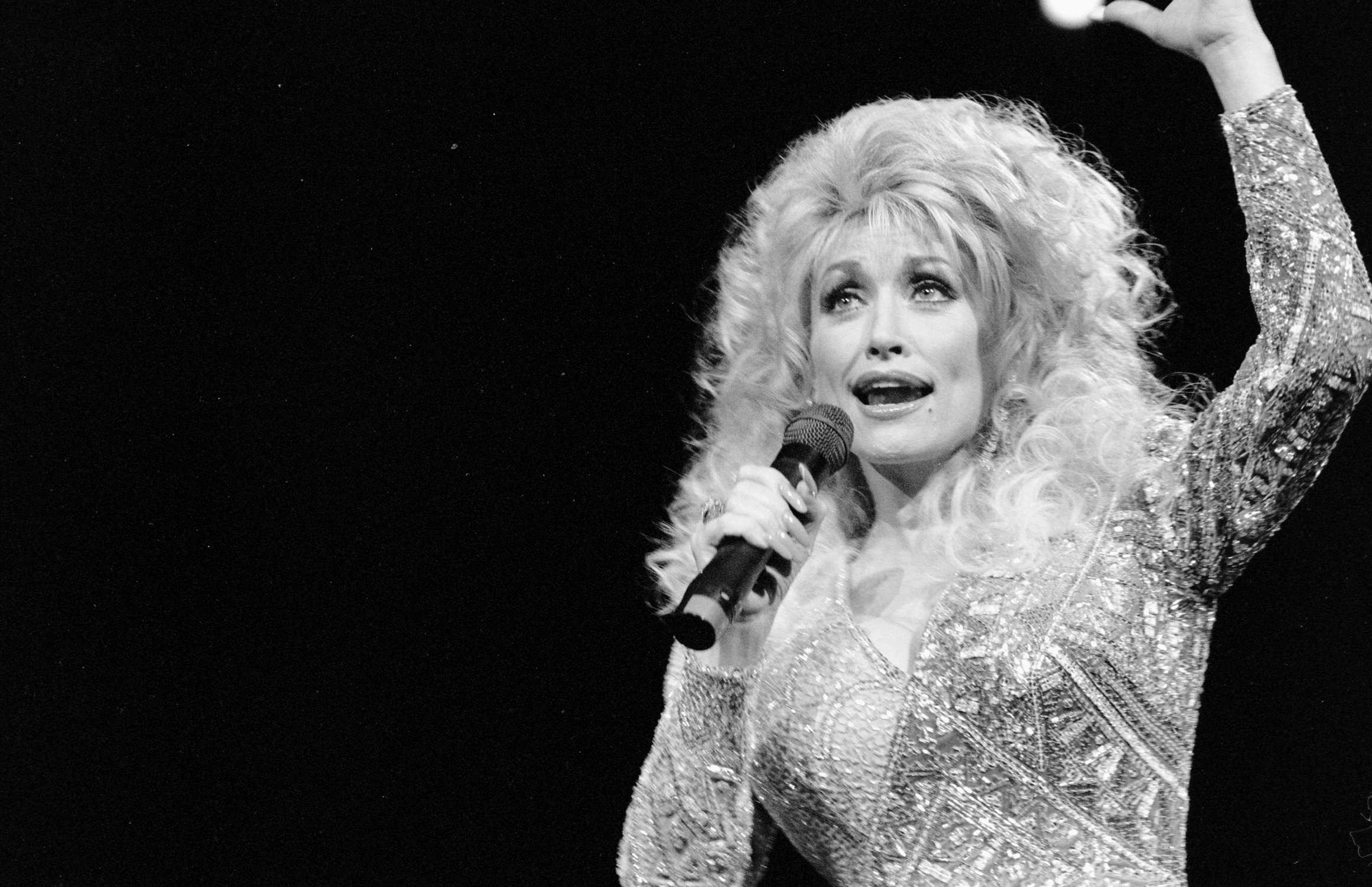 Dolly Parton performing in black and white.
