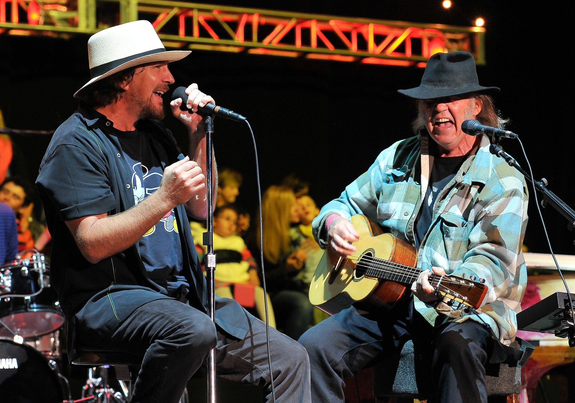 Eddie Vedder sits with Neil Young on stage