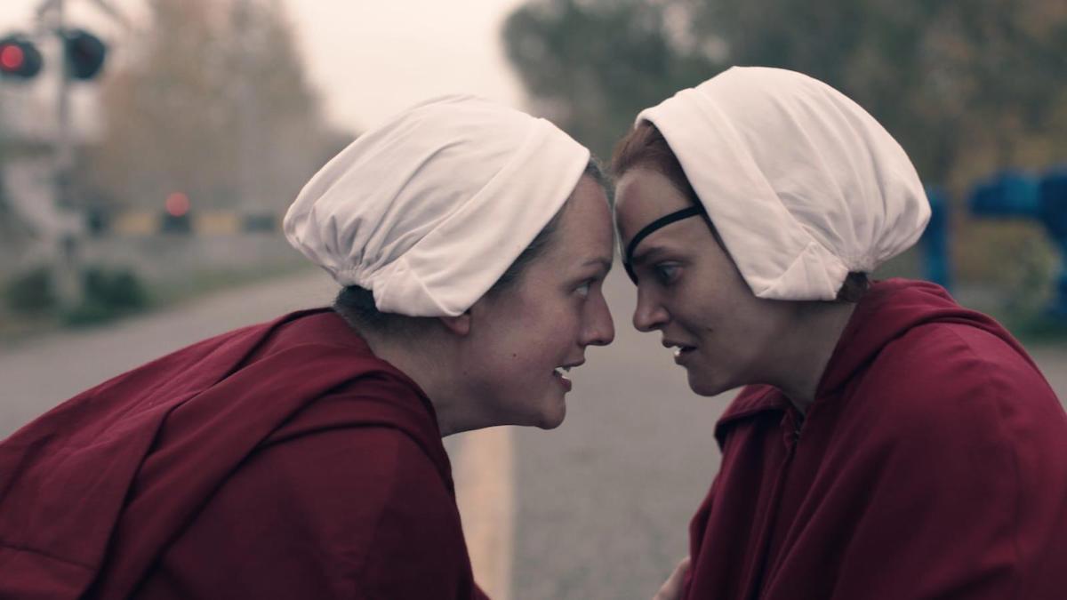 Elisabeth Moss as June Osborne and Madeline Brewer as Janine in red Handmaids robes and white bonnets in 'The Handmaid's Tale' Season 4 Episode 4, 'Milk'