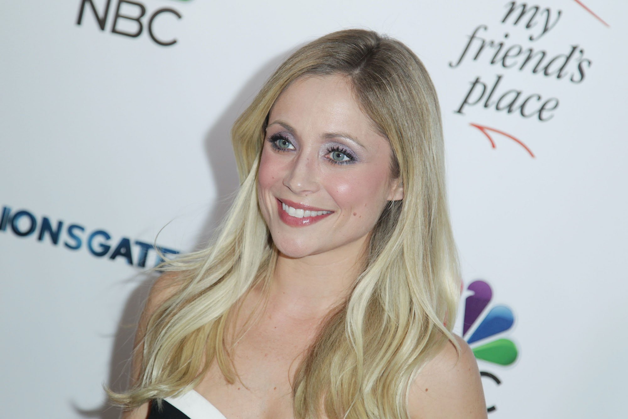 Emme Rylan smiling in front of a white background