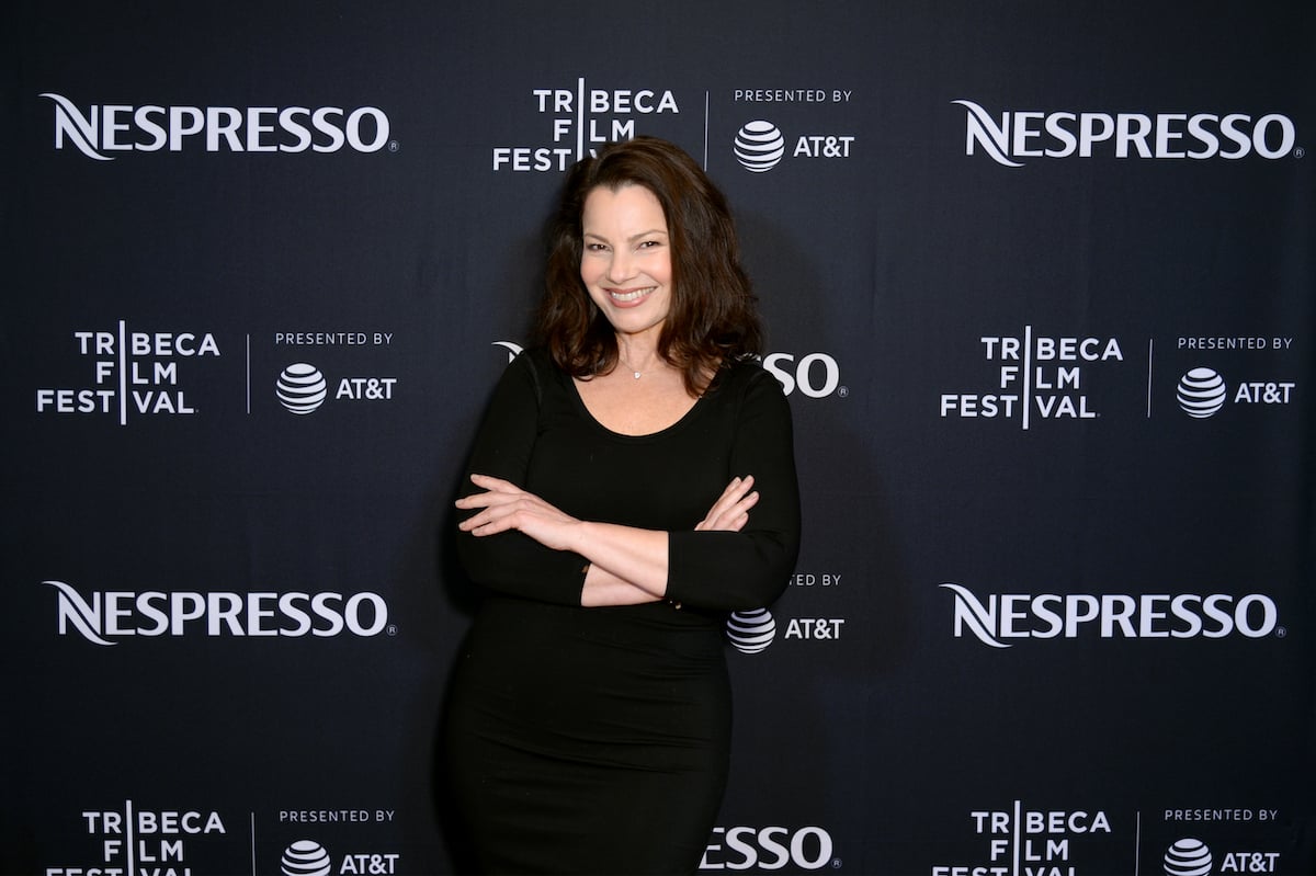 Fran Drescher smiles with her arms folded on the red carpet