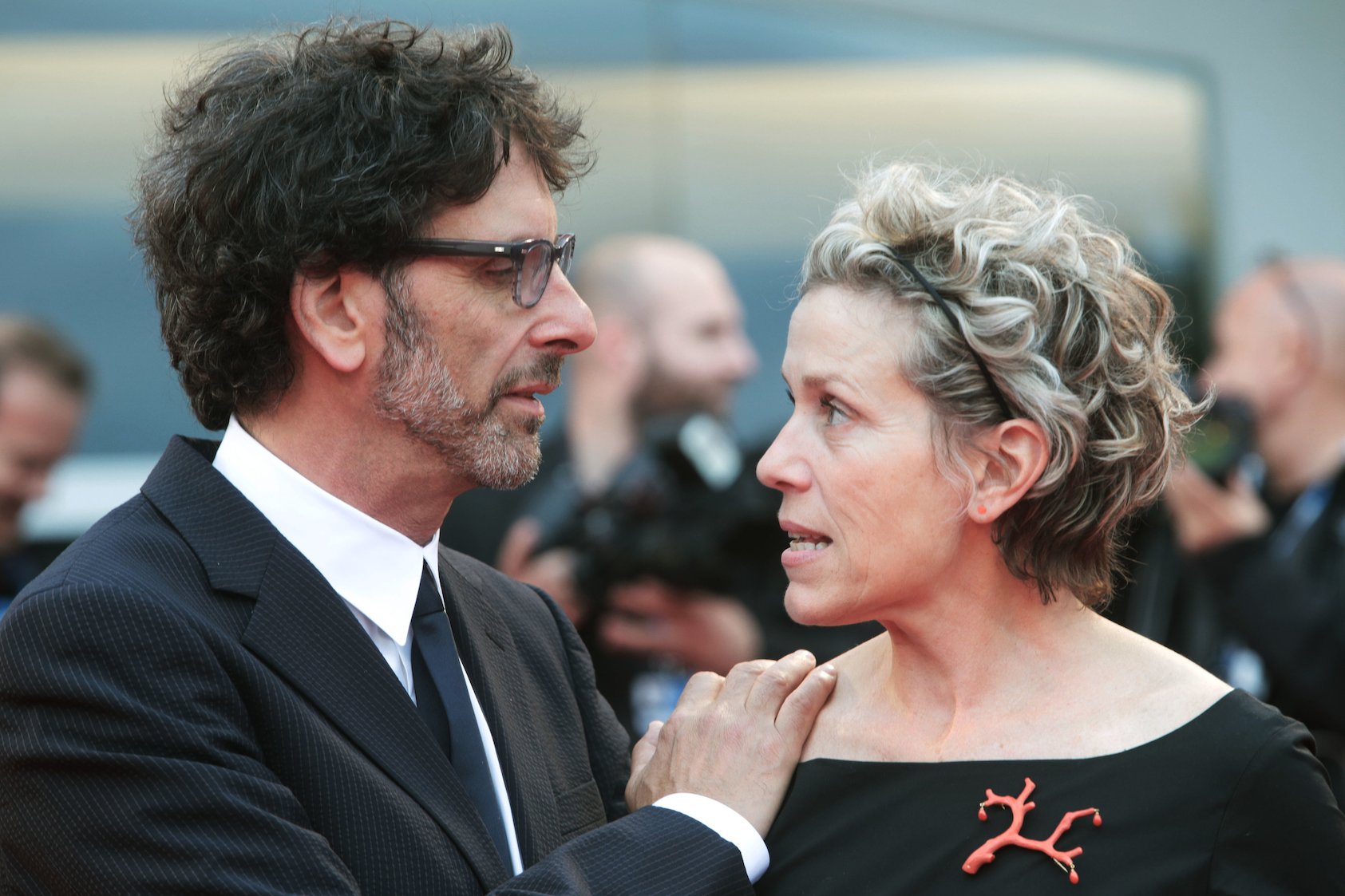 Frances McDormand looking at her husband, Joel Coen, at a movie premiere