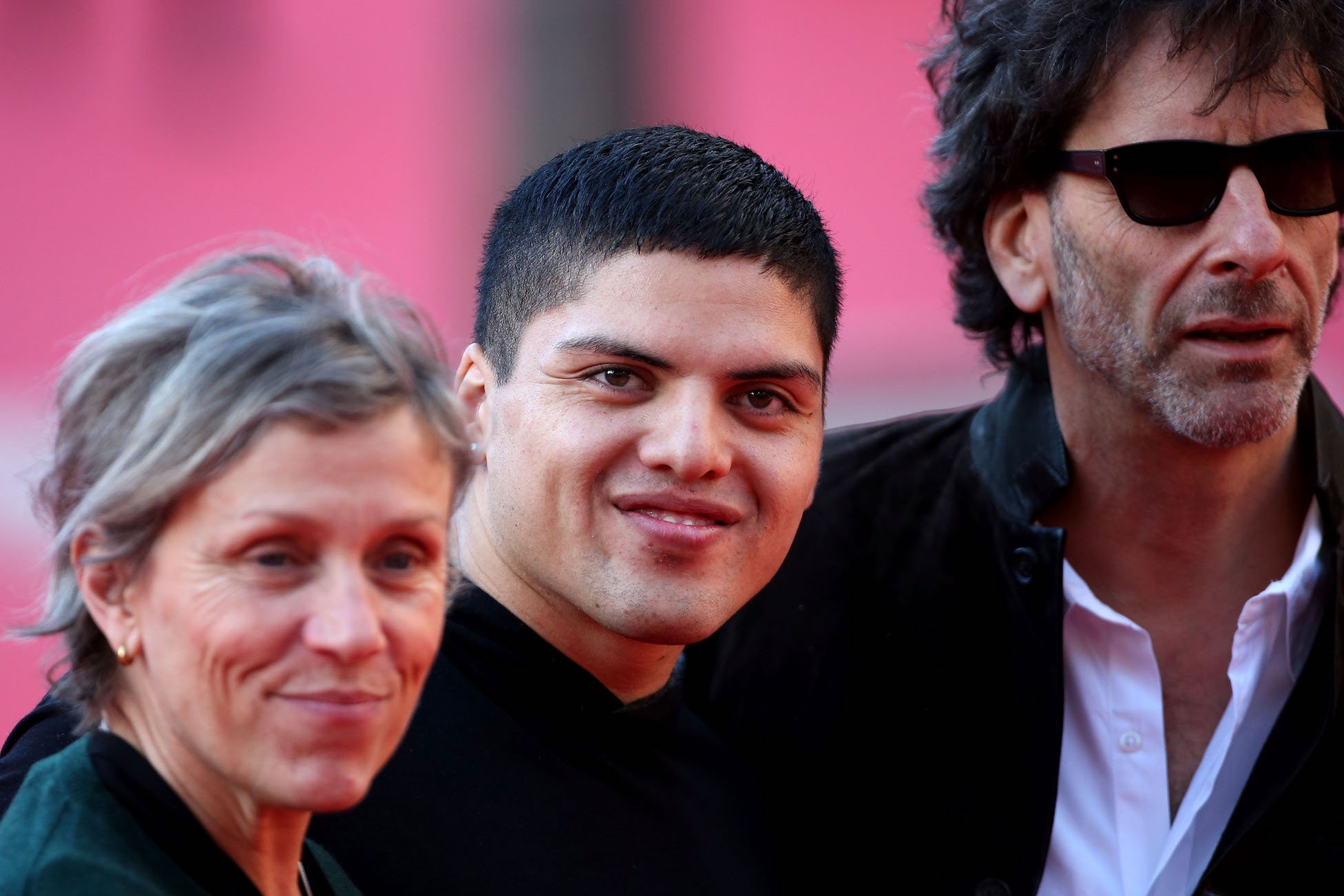Frances McDormand, her son, and her husband, Joel Coen, standing together at an event