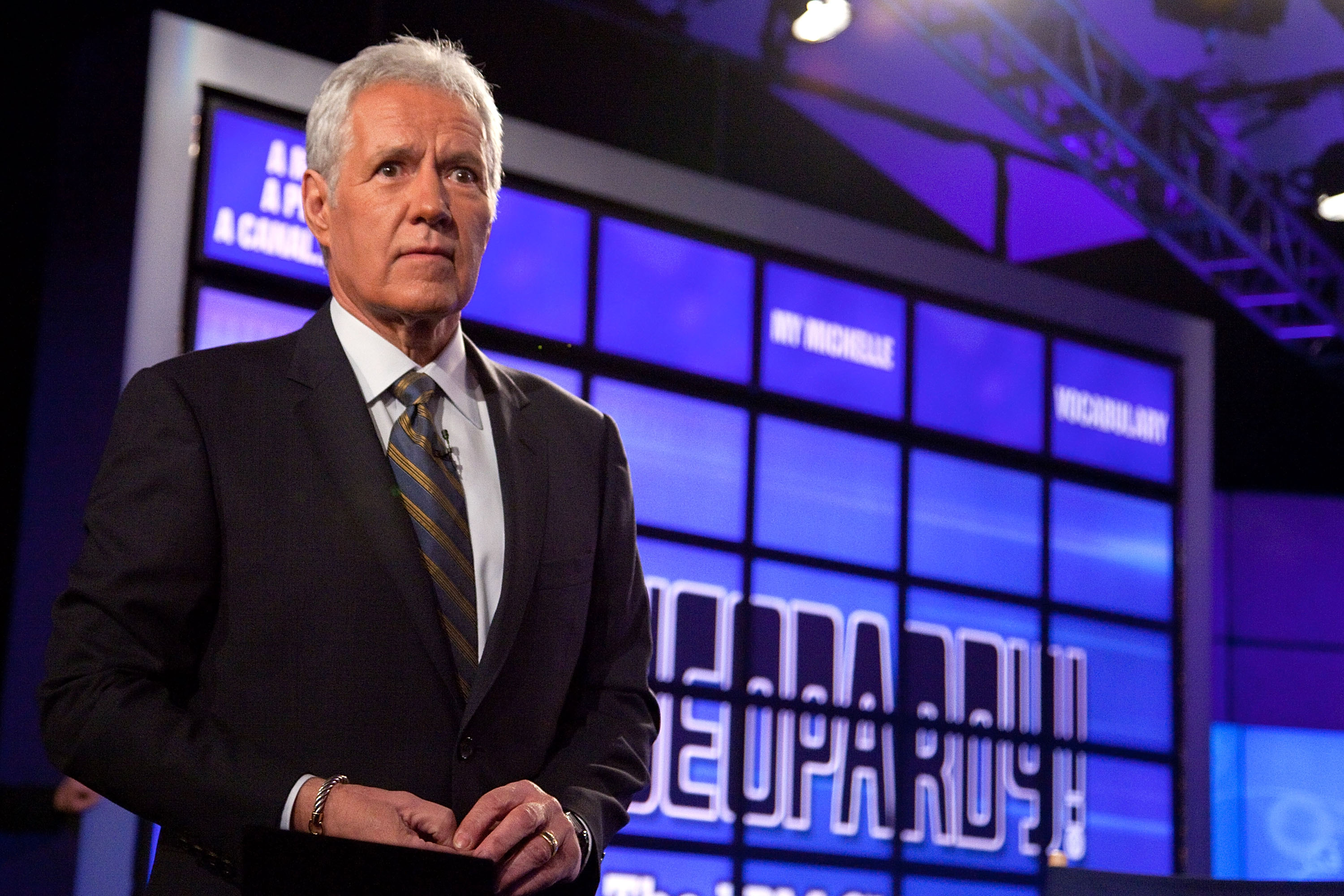 The late 'Jeopardy!' host Alex Trebek speaks while standing in front of the game show board, 2011