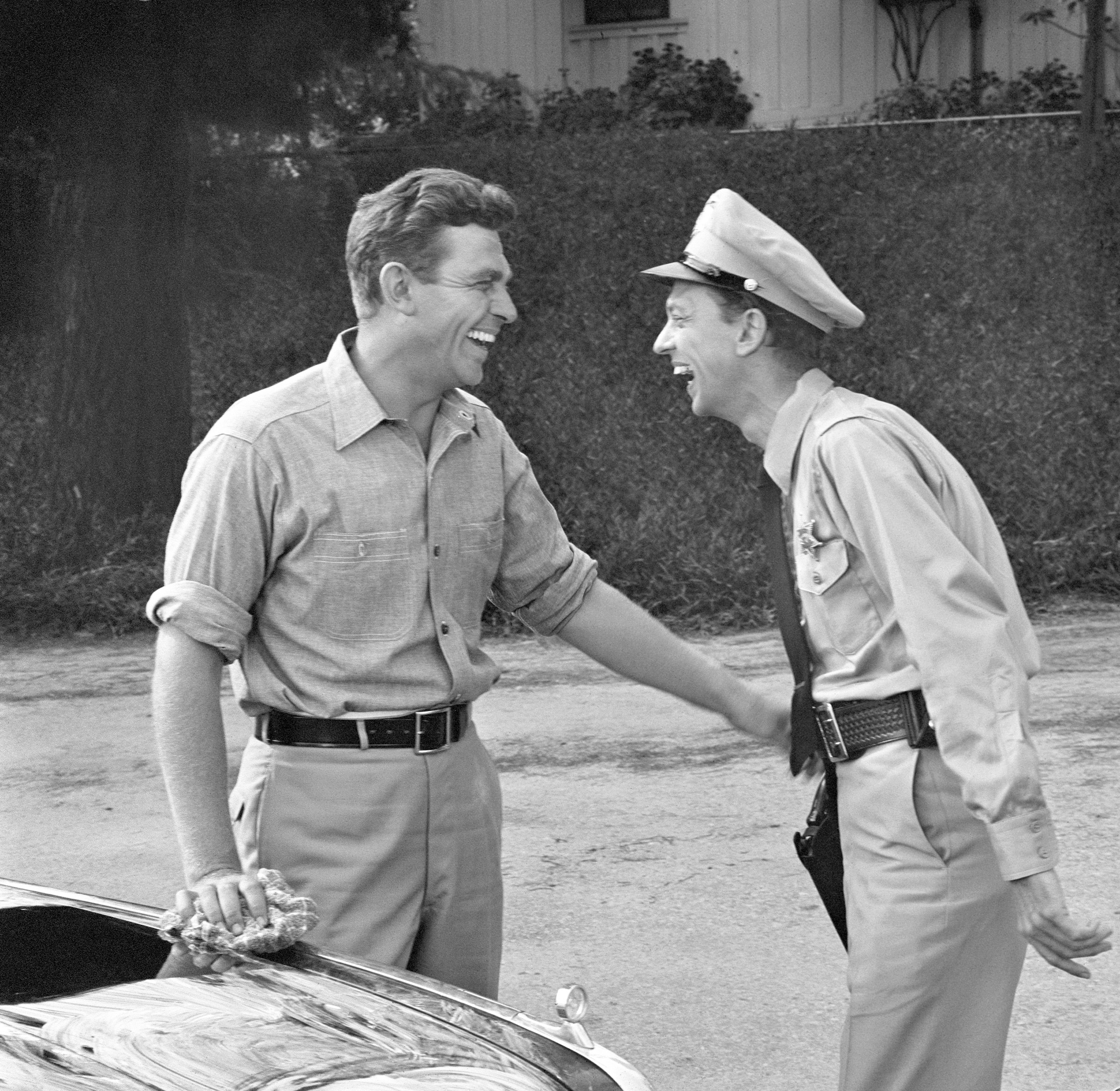 Andy Griffith and Don Knotts laugh together in a scene from the first episode of 'The Andy Griffith Show,' 1960