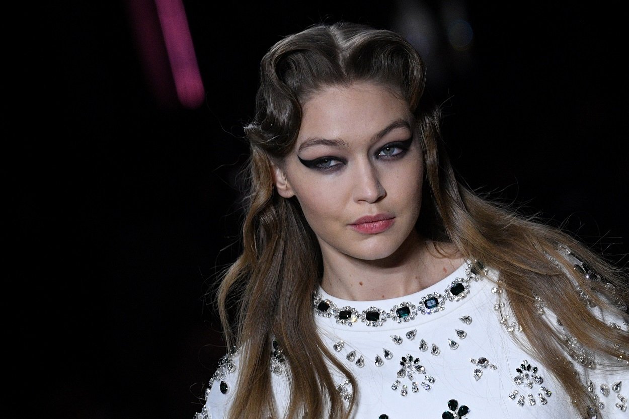 model Gigi Hadid in heavy winged eye look presents an award for Miu Miu