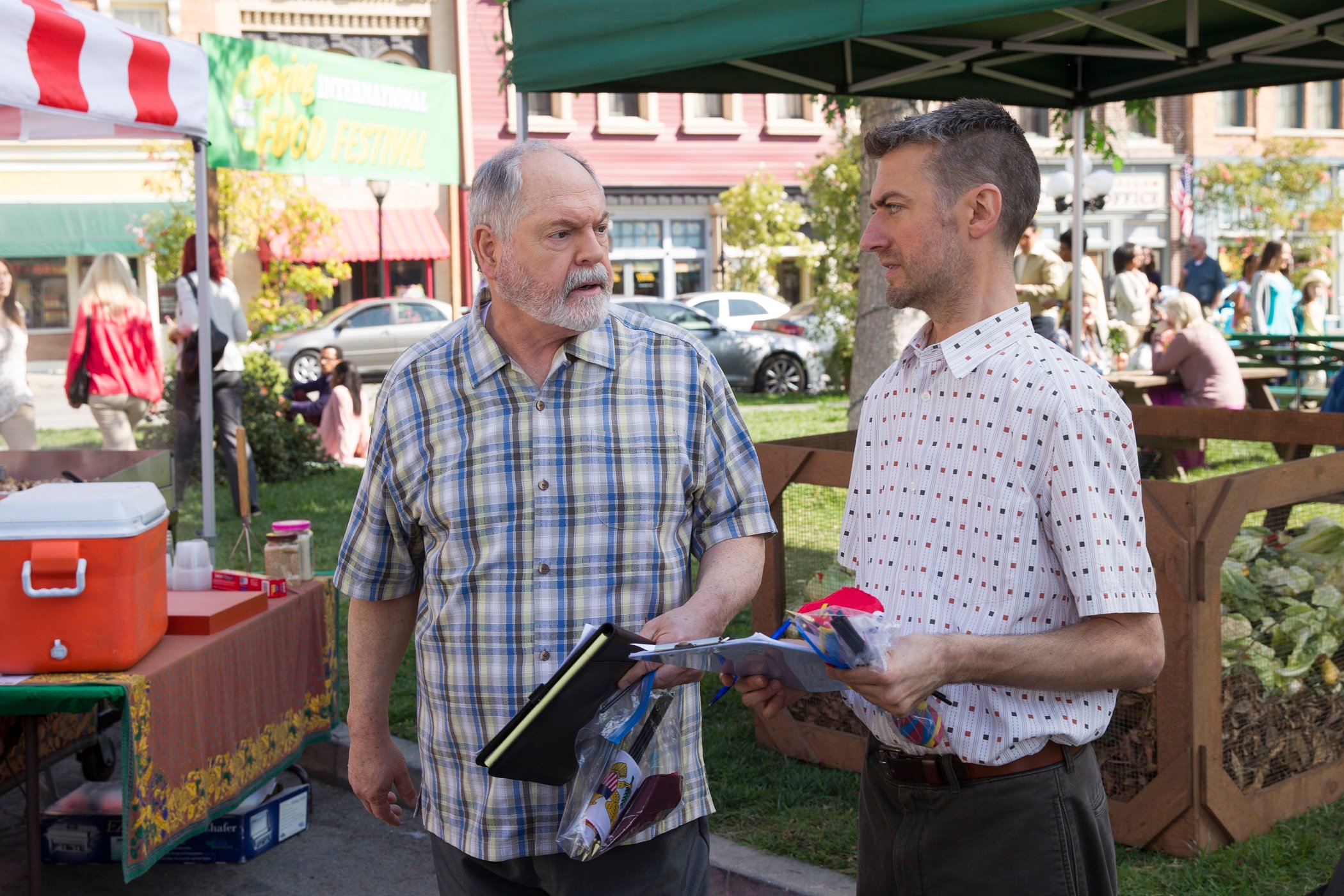Michael Winters as Taylor Doosey and Sean Gunn as Kirk Gleason discuss town business in Stars Hollow's town center