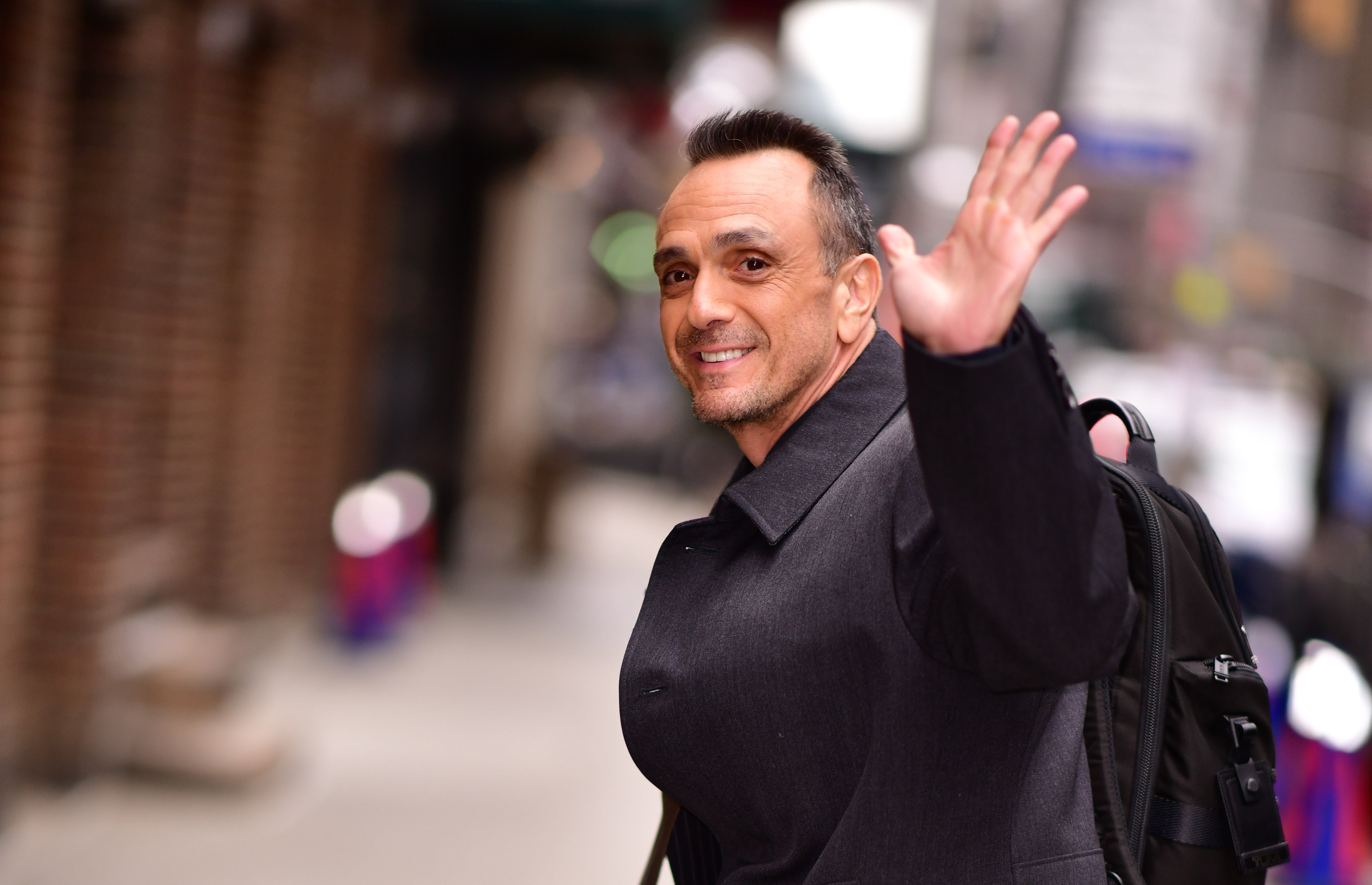 Hank Azaria waving in the street