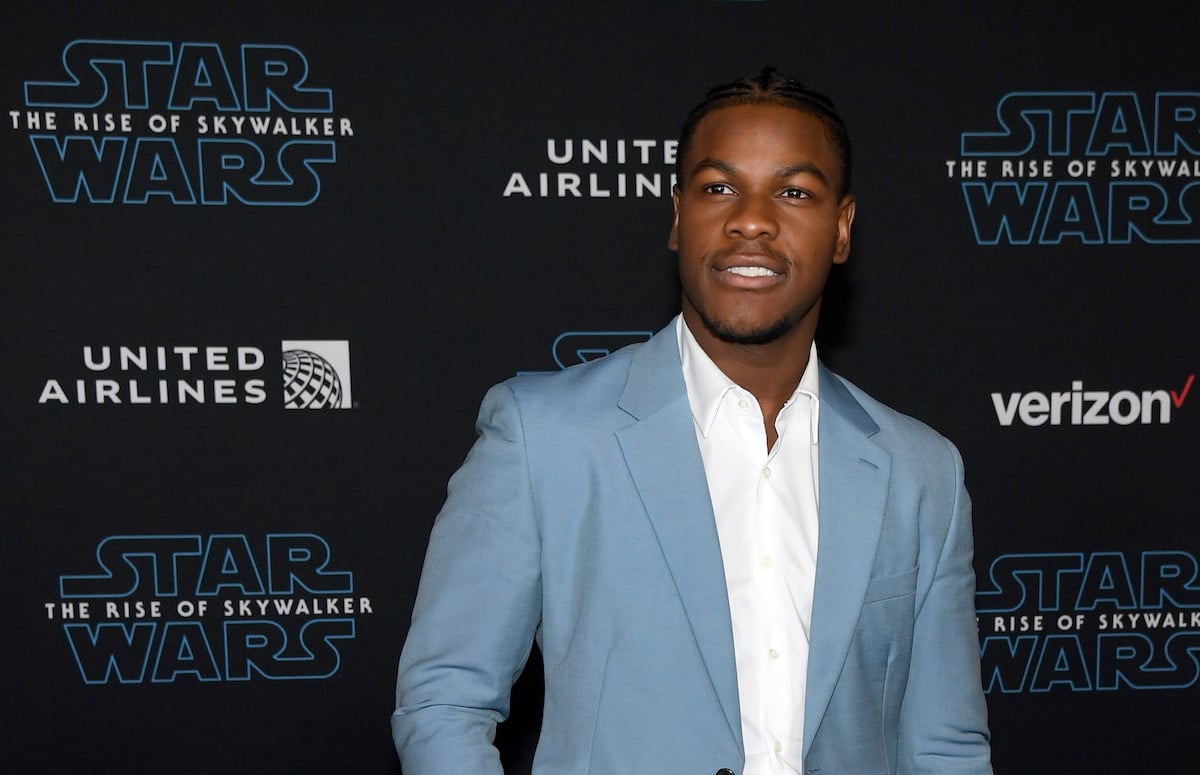 Actor John Boyega smiles on the red carpet wearing a baby blue blazer