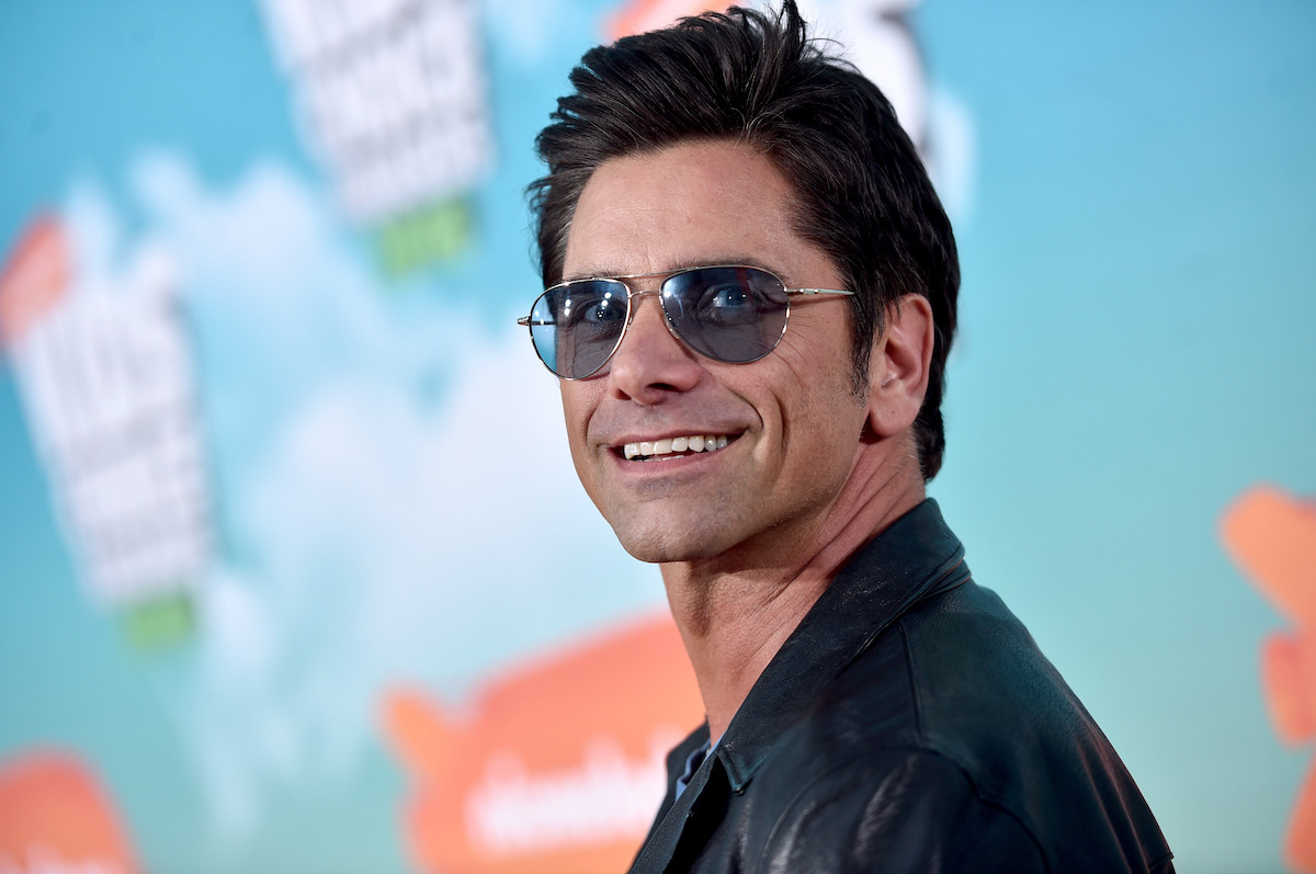 John Stamos wears sunglasses and smiles