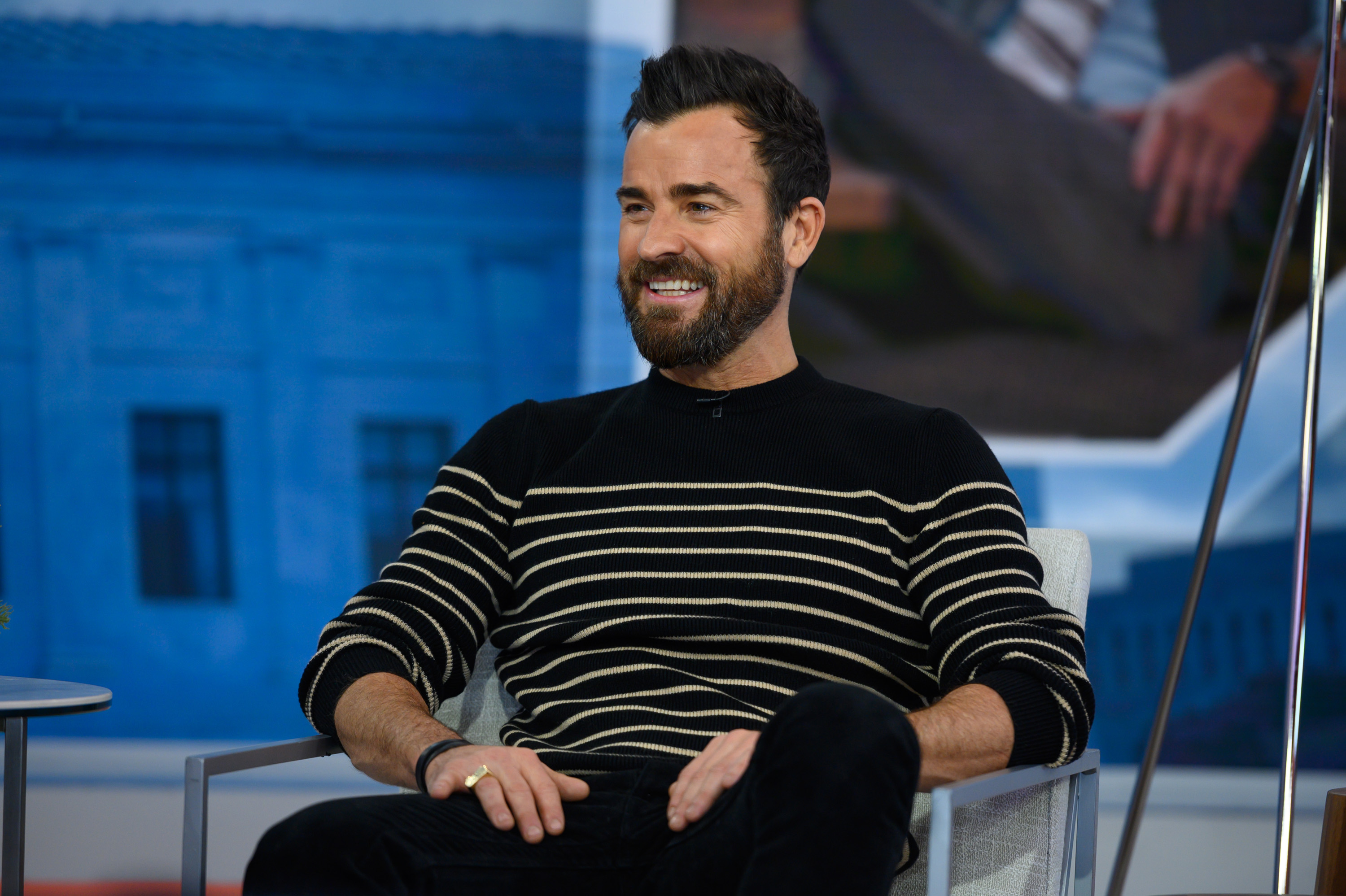 Justin Theroux sitting on the set of the 'Today' show in  a black striped sweater