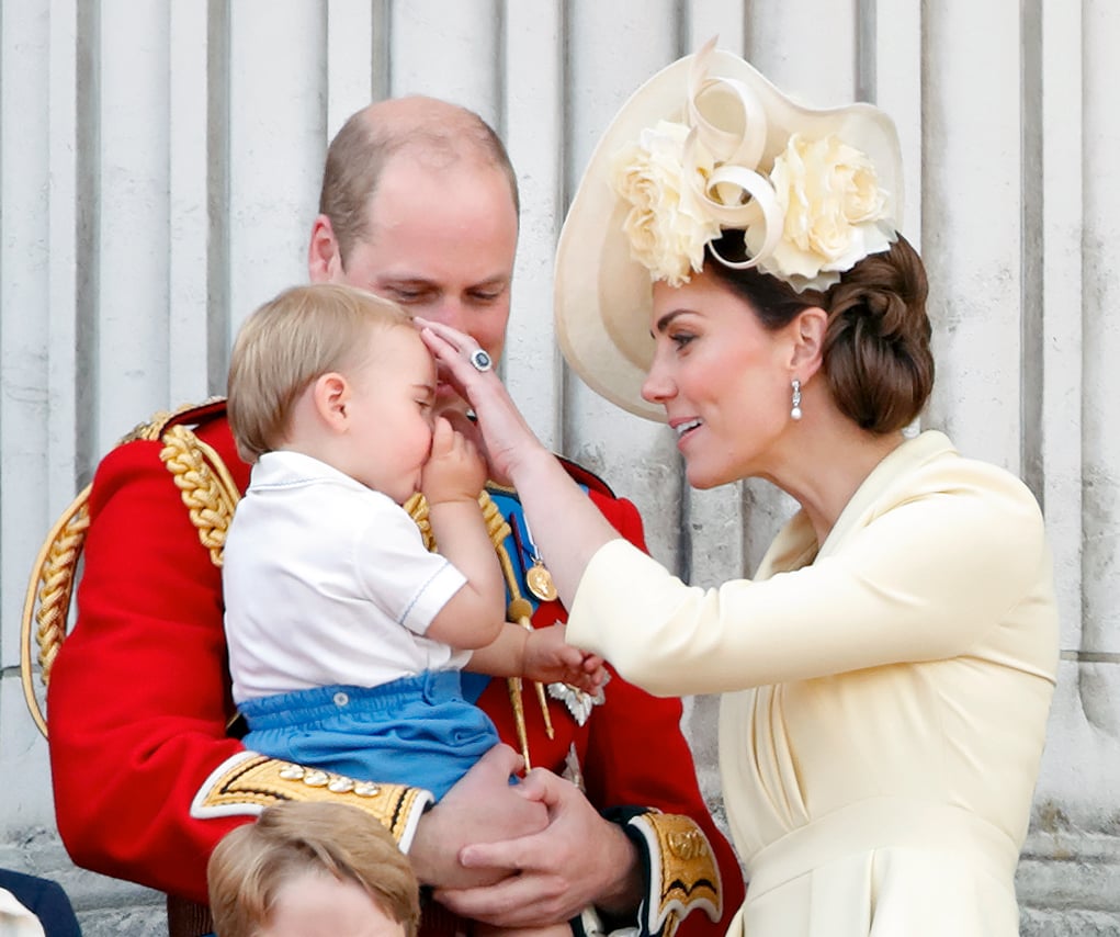 Kate Middleton gently touches Prince Louis' head as Prince William holds him on the Buckingham Palace balcony during Trooping the Colour