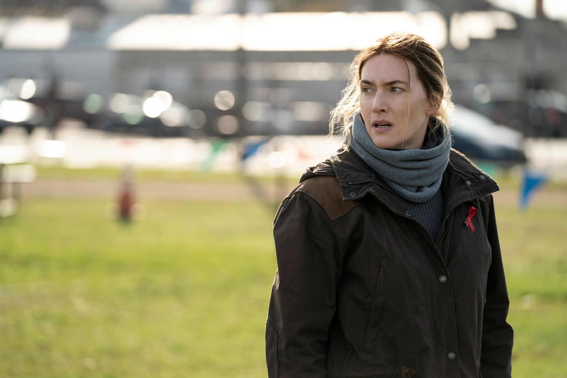 Kate Winslet stands on the grass during a scene from 'Mare of Easttown'