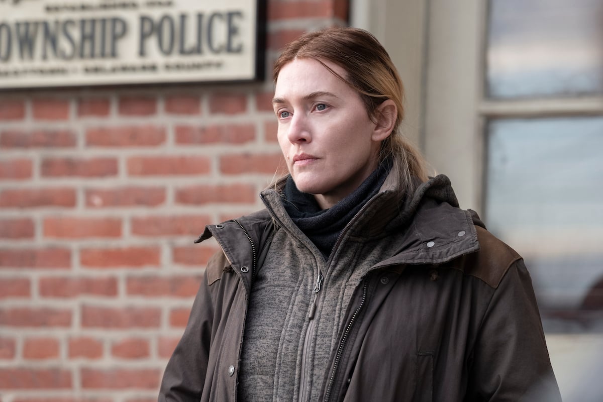 Kate Winslet stands outside of a brick building on 'Mare of Easttown'