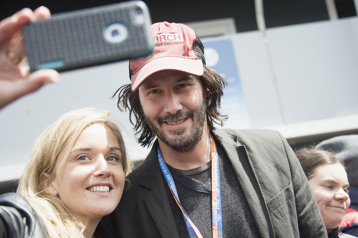 Keanu Reeves poses with a fan at the 2016 MotoGP of Australia at Phillip Island Grand Prix Circuit in Phillip Island, Australia