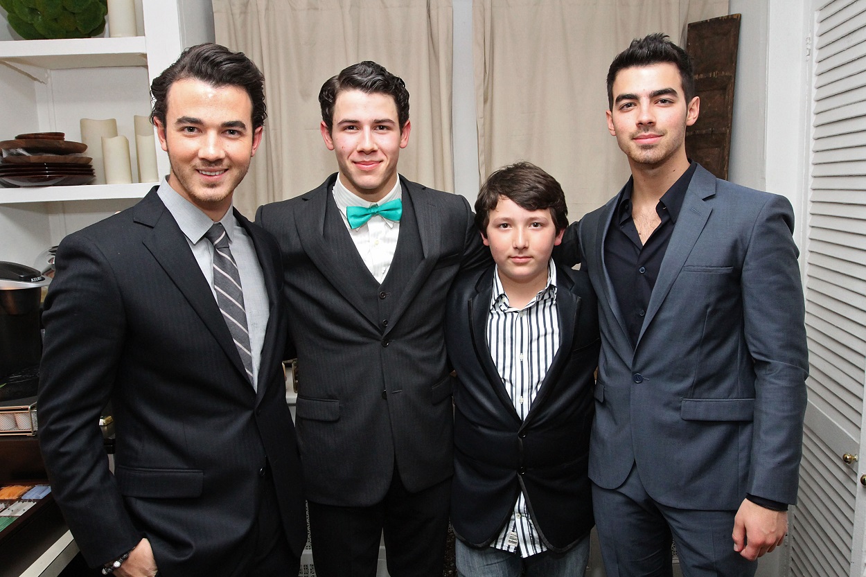 Kevin Jonas, Nick Jonas, Frankie Jonas, and Joe Jonas pose in suits