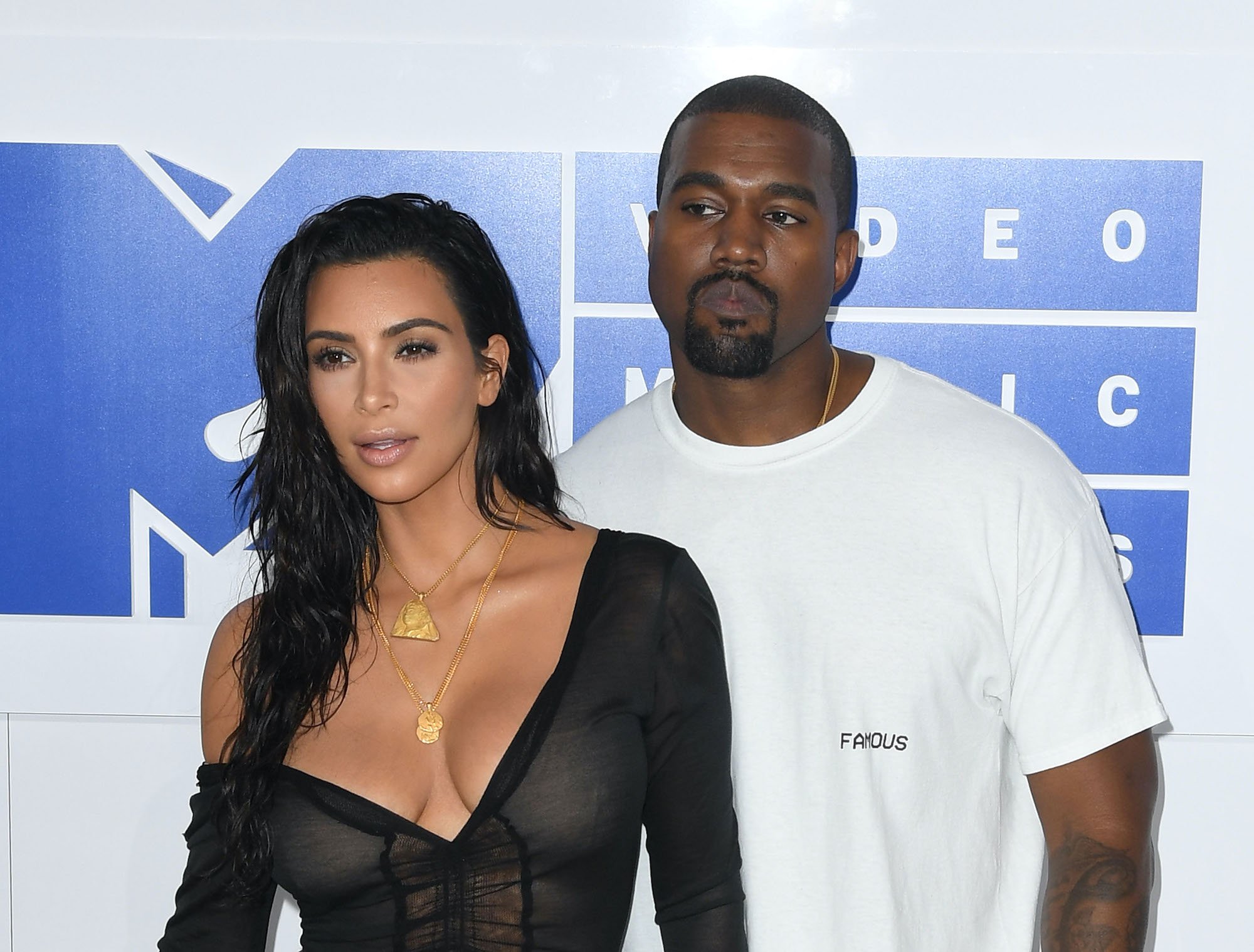 (L-R) Kim Kardashian and Kanye West in front of a white background