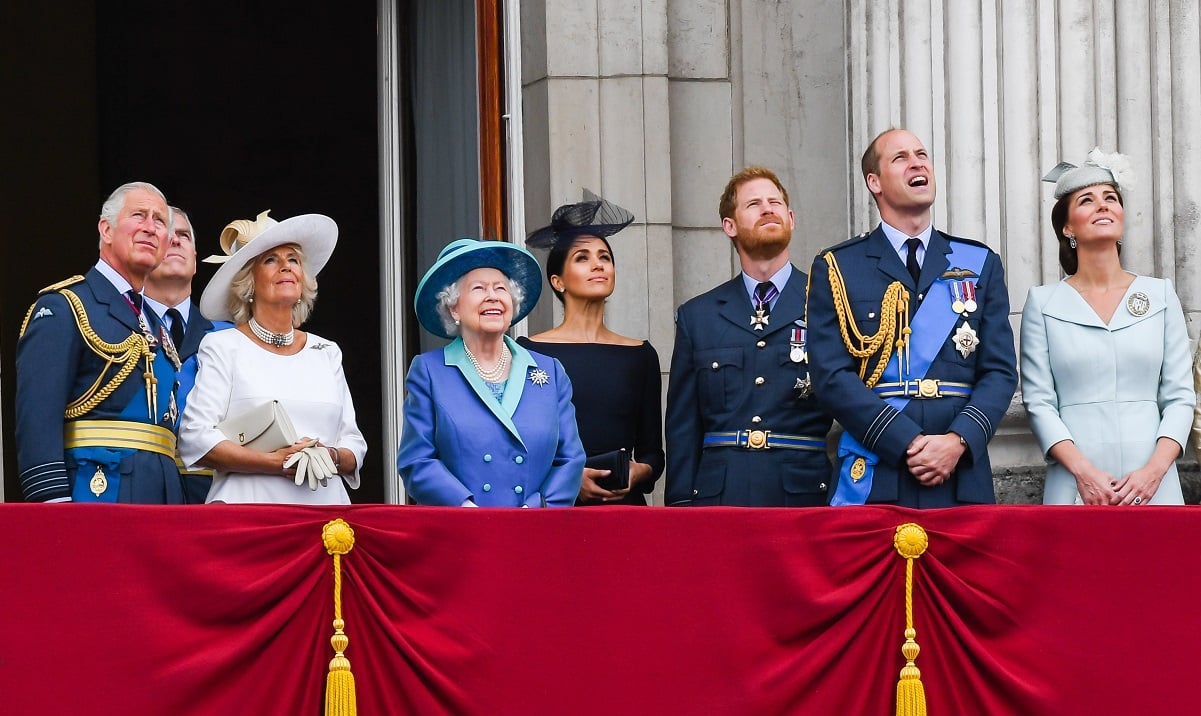 (L-R)Prince Charles, Camilla Parker Bowles, Prince Andrew, Queen Elizabeth ll, Meghan Markle, Prince Harry, Prince William, and Kate Middleton standing on the balcony of Buckingham Palace watching a flypast