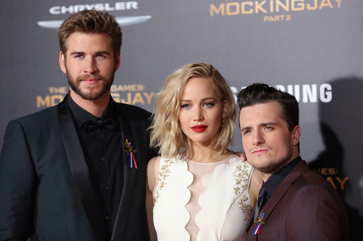 The Hunger Games main cast" Liam Hemsworth, Jennifer Lawrence, and Josh Hutcherson pose on the red carpet for the final film