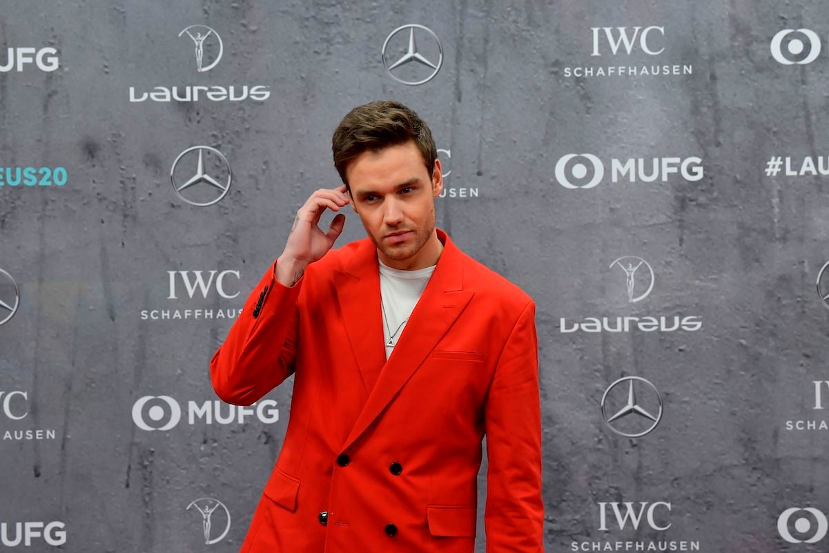 Liam Payne poses in a red suit on a red carpet