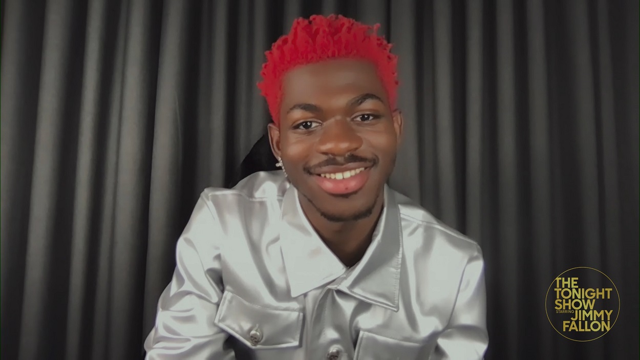 Lil Nas X sporting red hair smiles at the camera during a recording of The Tonight Show Starring Jimmy Fallon