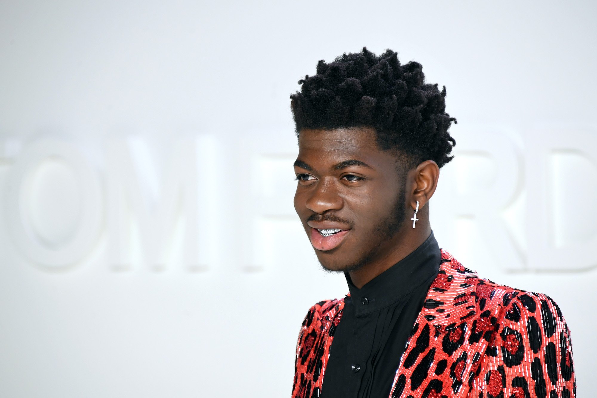 Lil Nas X smiling in front of a white background