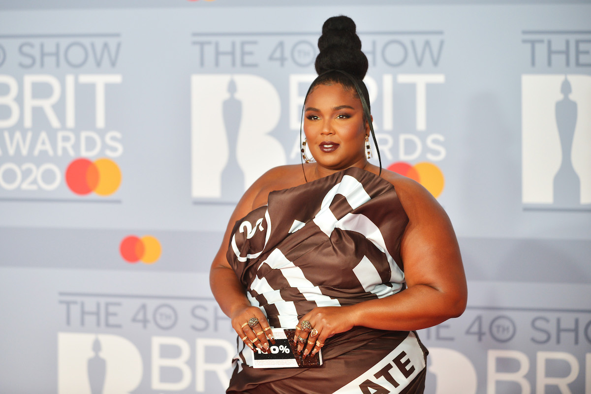 Lizzo in a brown dress and rings