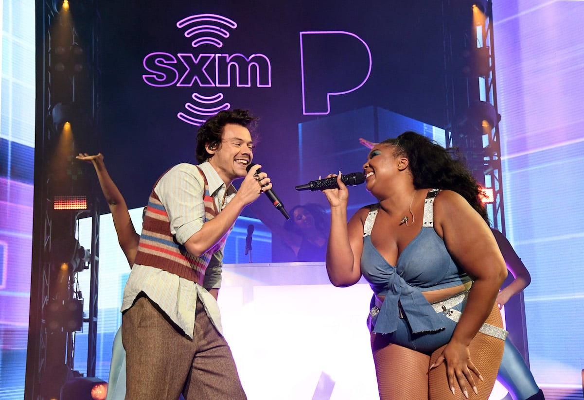 Harry Styles and Lizzo smiling at each other while singing together