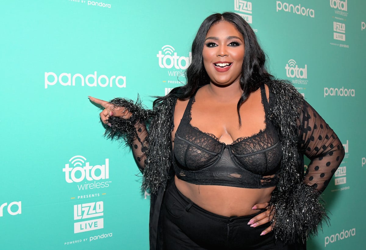 Lizzo smiles and points her finger wearing black