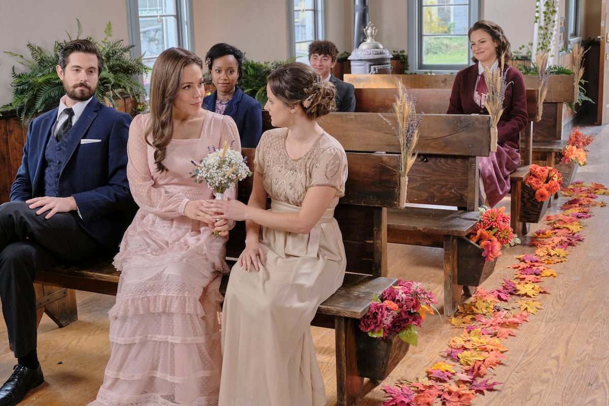 Lucas, Elizabeth, and Kate sitting on a pew in church in episode of When Calls the Heart