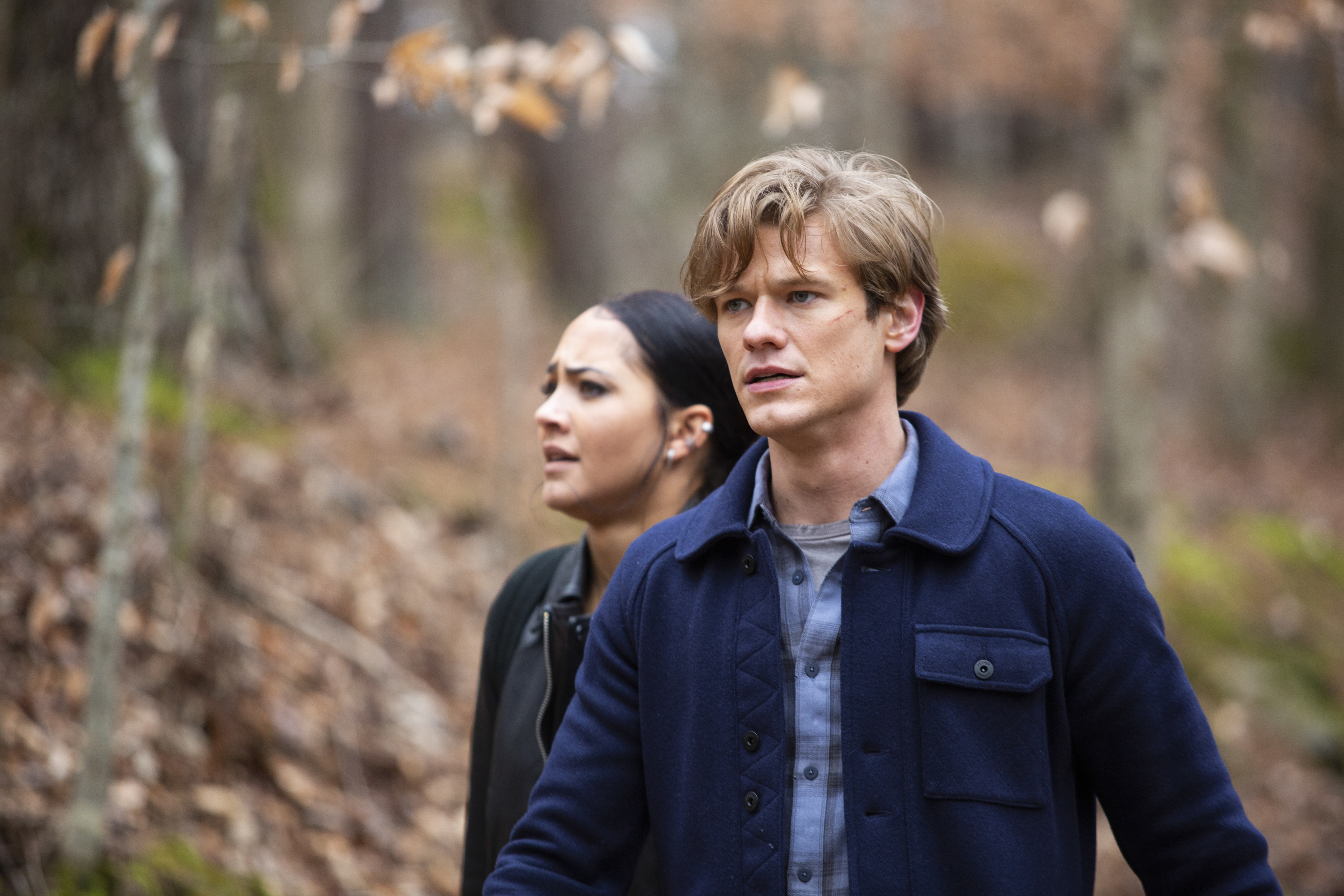 Lucas Till and MacGyver and Tristin Mays as Riley Davis standing in the woods 