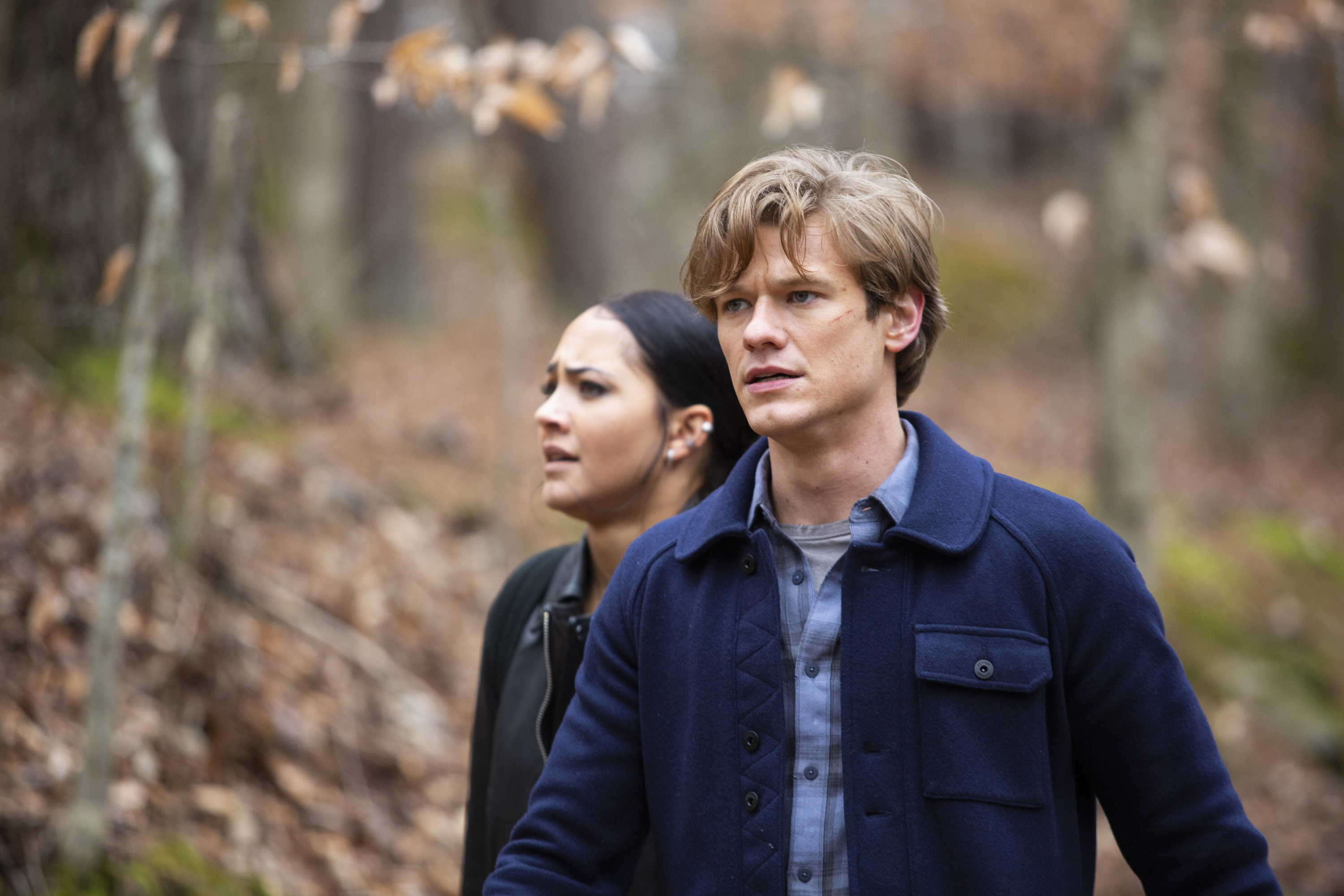 Lucas Till and MacGyver and Tristin Mays as Riley Davis standing in the woods