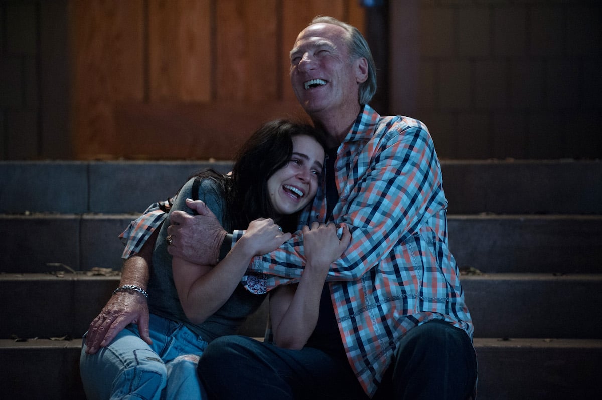Mae Whitman and Craig T. Nelson embrace while sitting on a set of stairs during a scene on 'Parenthood'