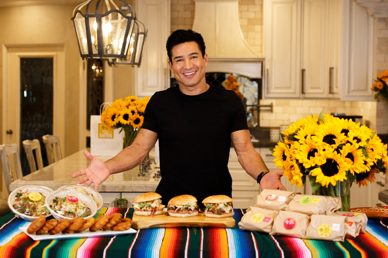 Mario Lopez of 'Access Hollywood' stands in front of items from his menu at Mario's Tortas Lopez