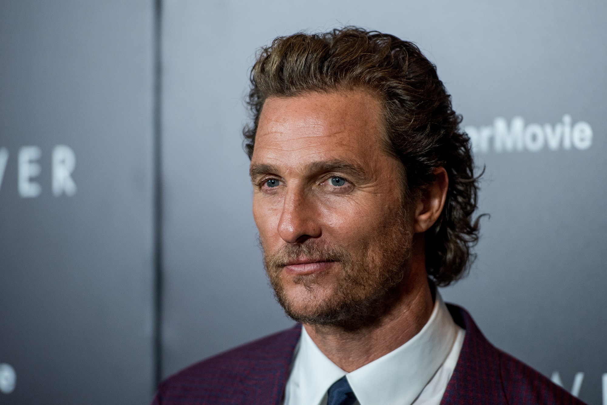 Matthew McConaughey looking on in front of gray background