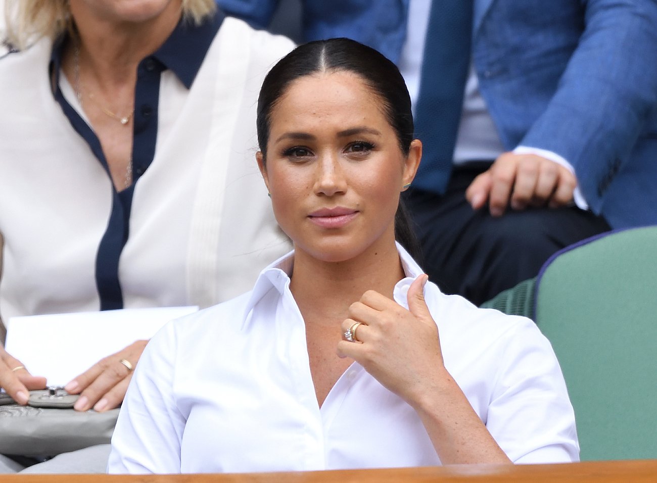 Meghan Markle wearing white shirt, looking on