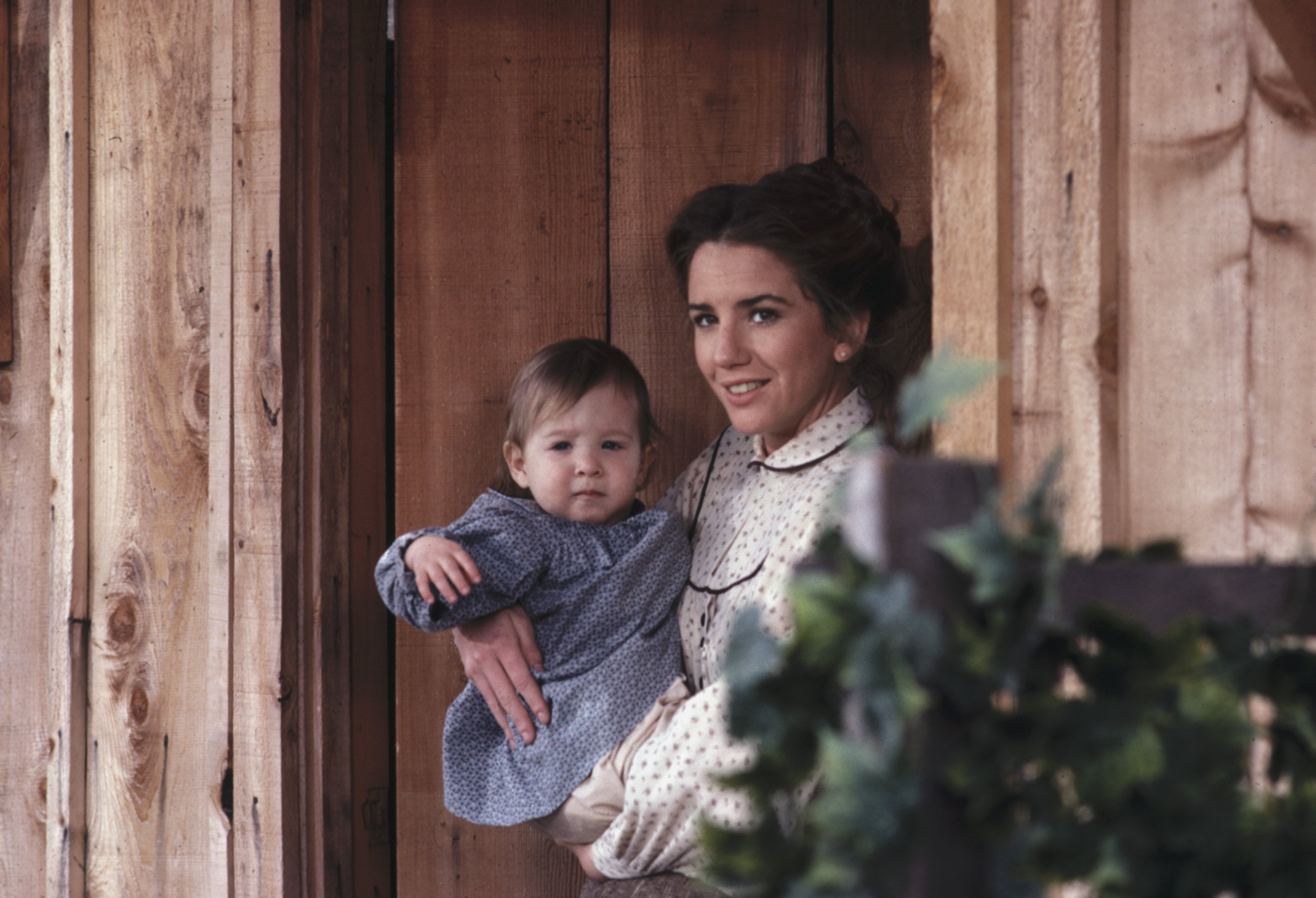 Melissa Gilbert as Laura Ingalls Wilder, holding her baby, on the set of 'Little House on the Prairie.'
