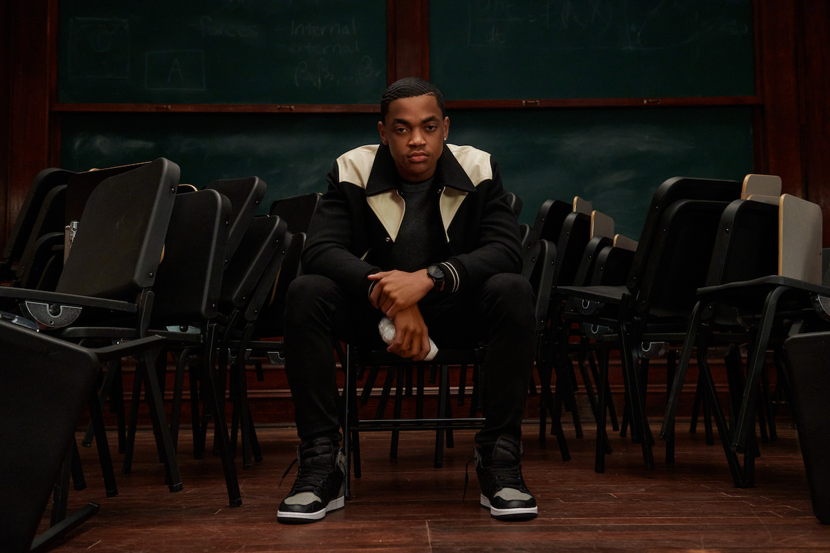Michael Rainey Jr as Tariq St. Patrick in 'Power Book II: Ghost' sitting down in a chair and staring at the camera