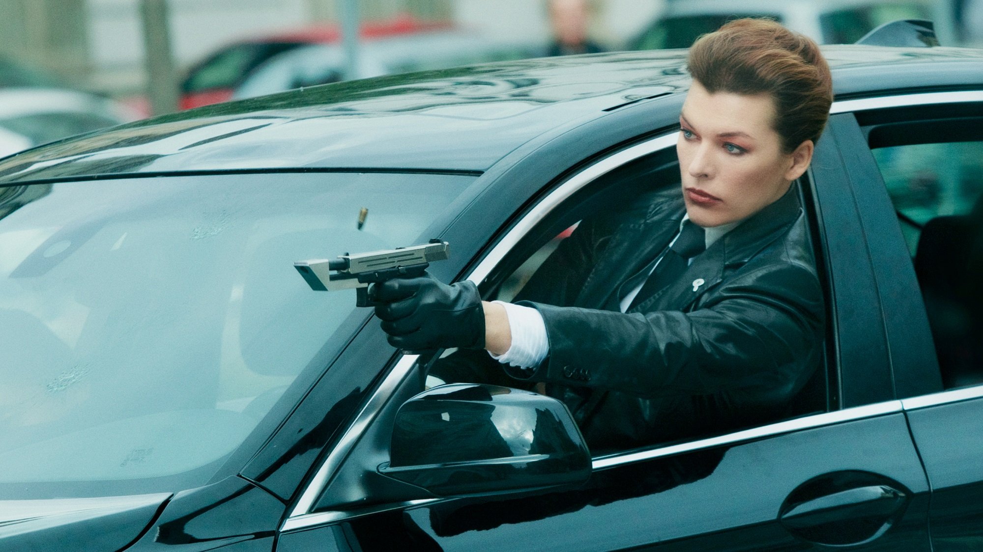 Milla Jovovich shoots a gun out a car window