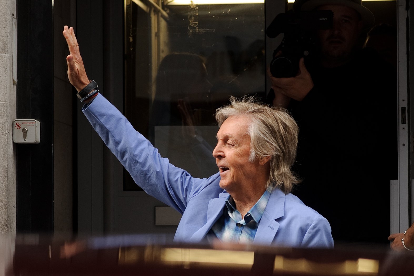 Paul McCartney waves to fans in London