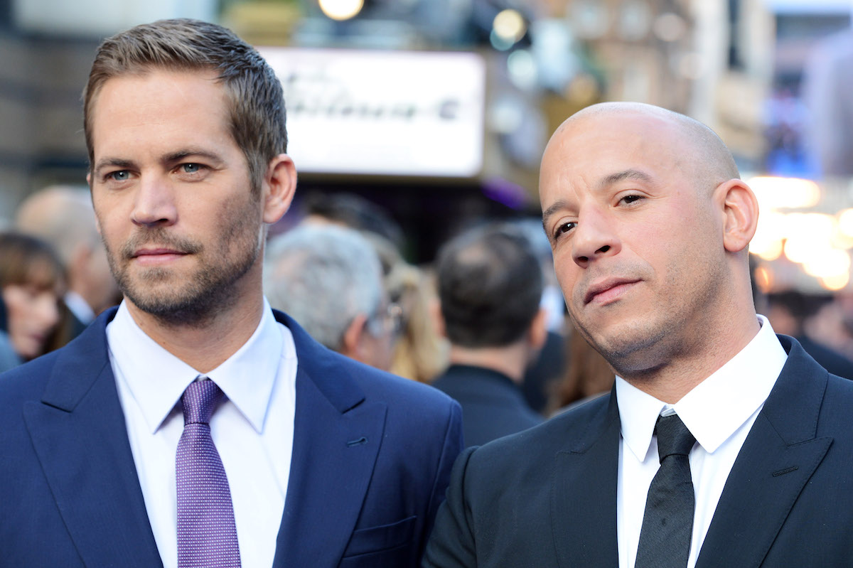 Paul Walker and Vin Diesel are wearing suits on a red carpet